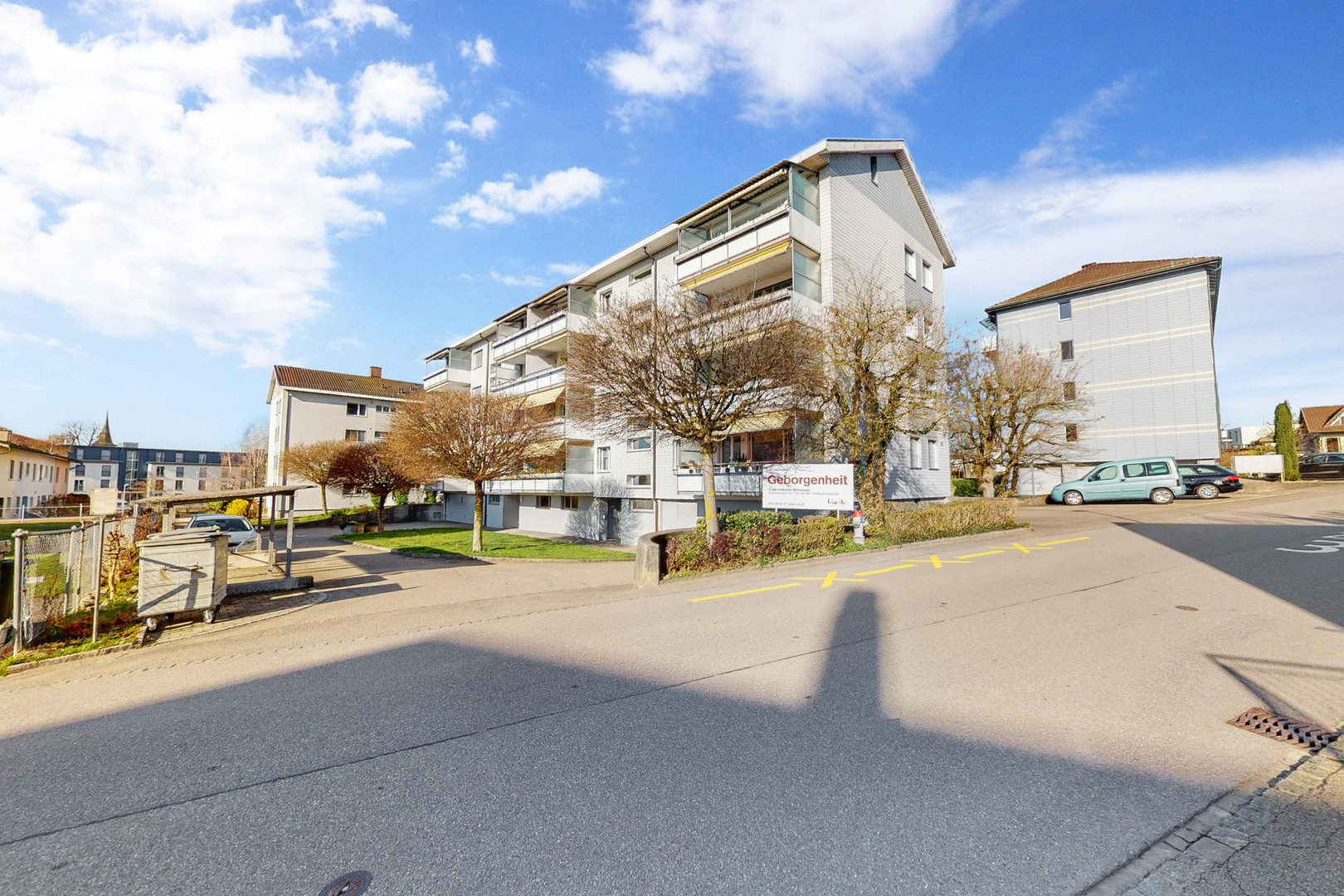 Mehrfamilienhaus mit Balkon und Straßenansicht