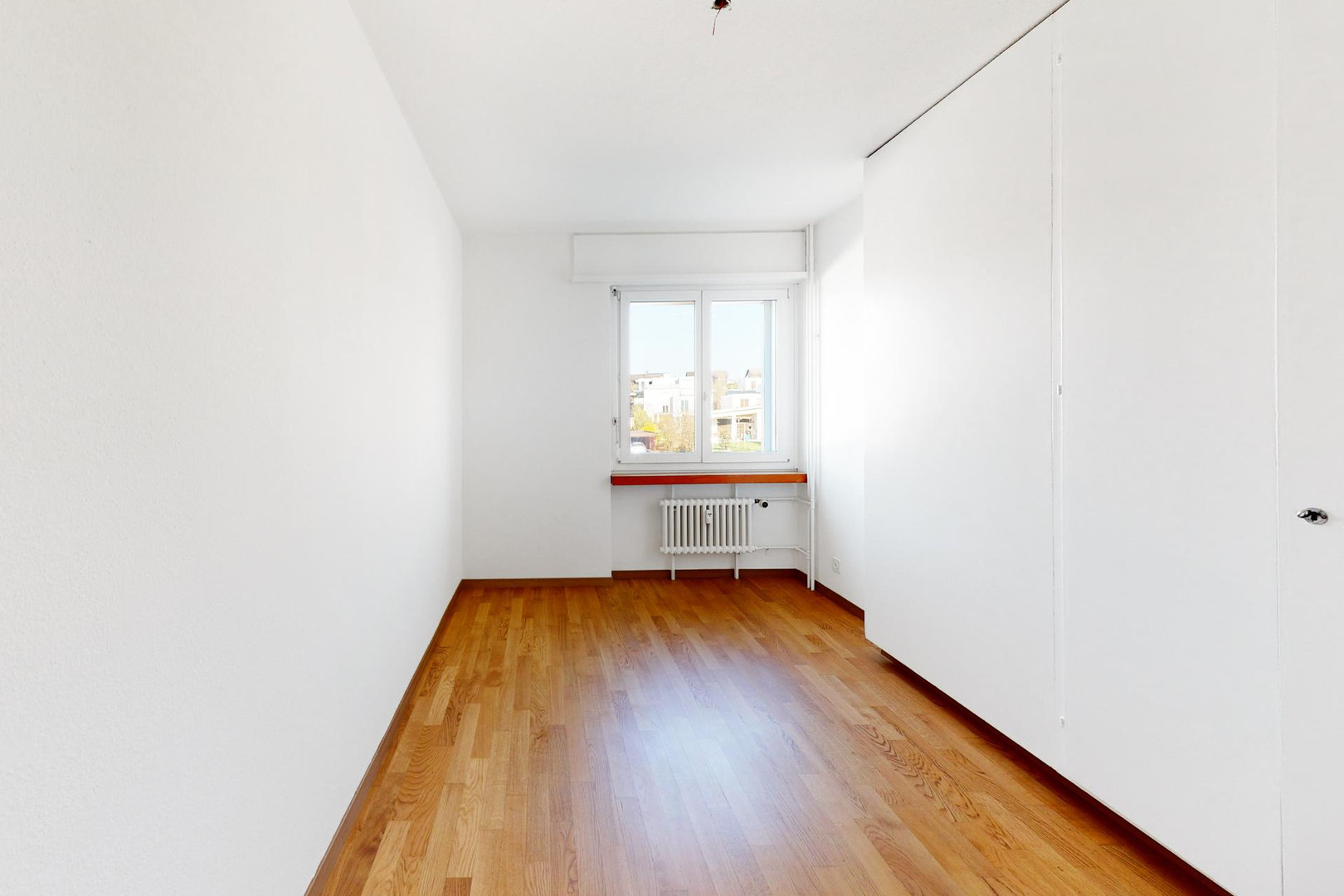 Schmales, helles Zimmer mit Parkettboden
