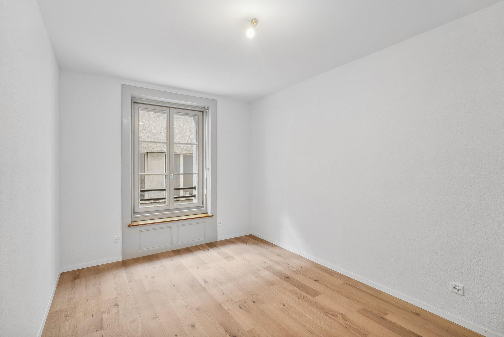 Helles, leeres Zimmer mit Fenster
