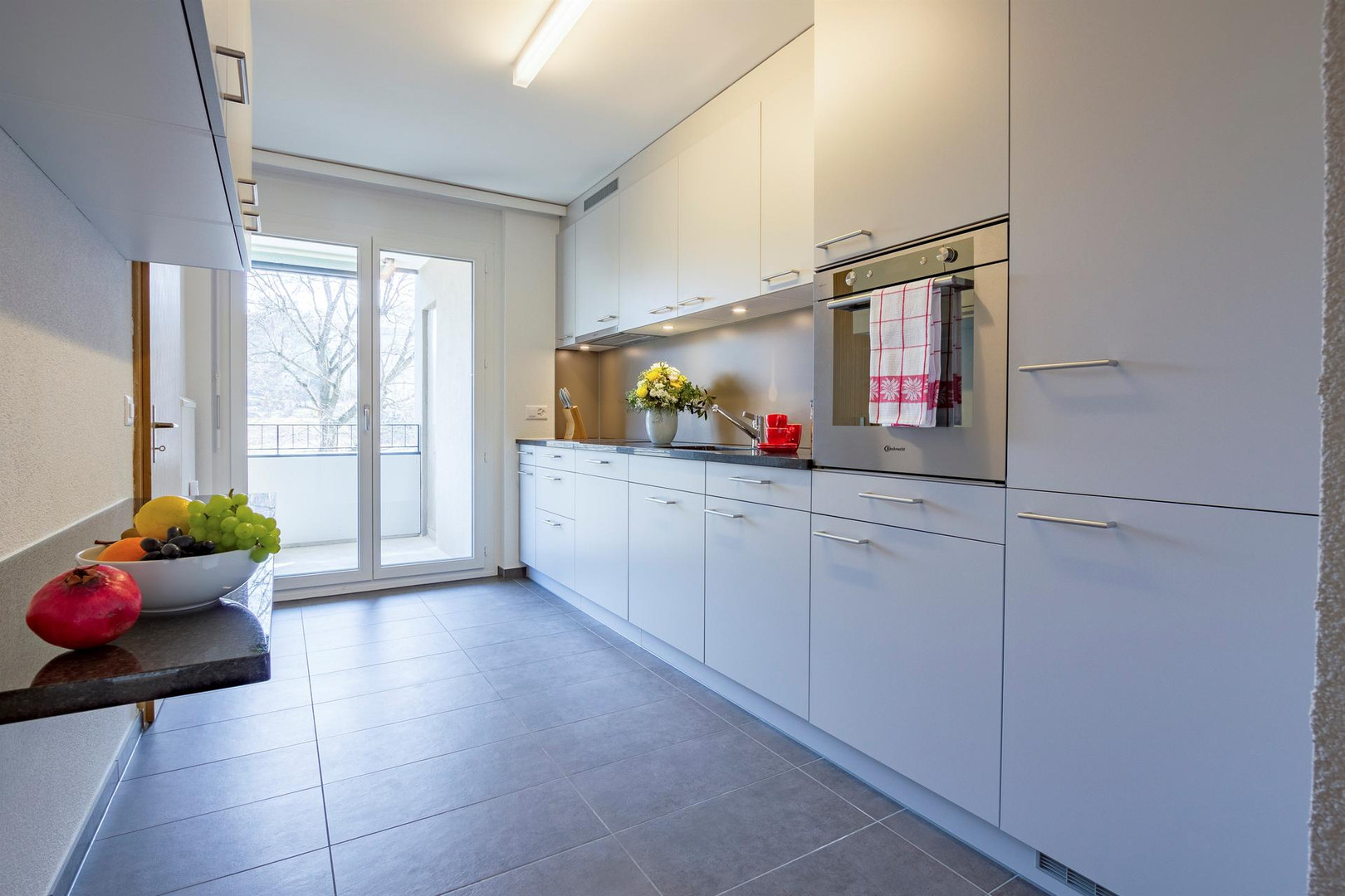 Moderne, helle Küche mit Balkonzugang