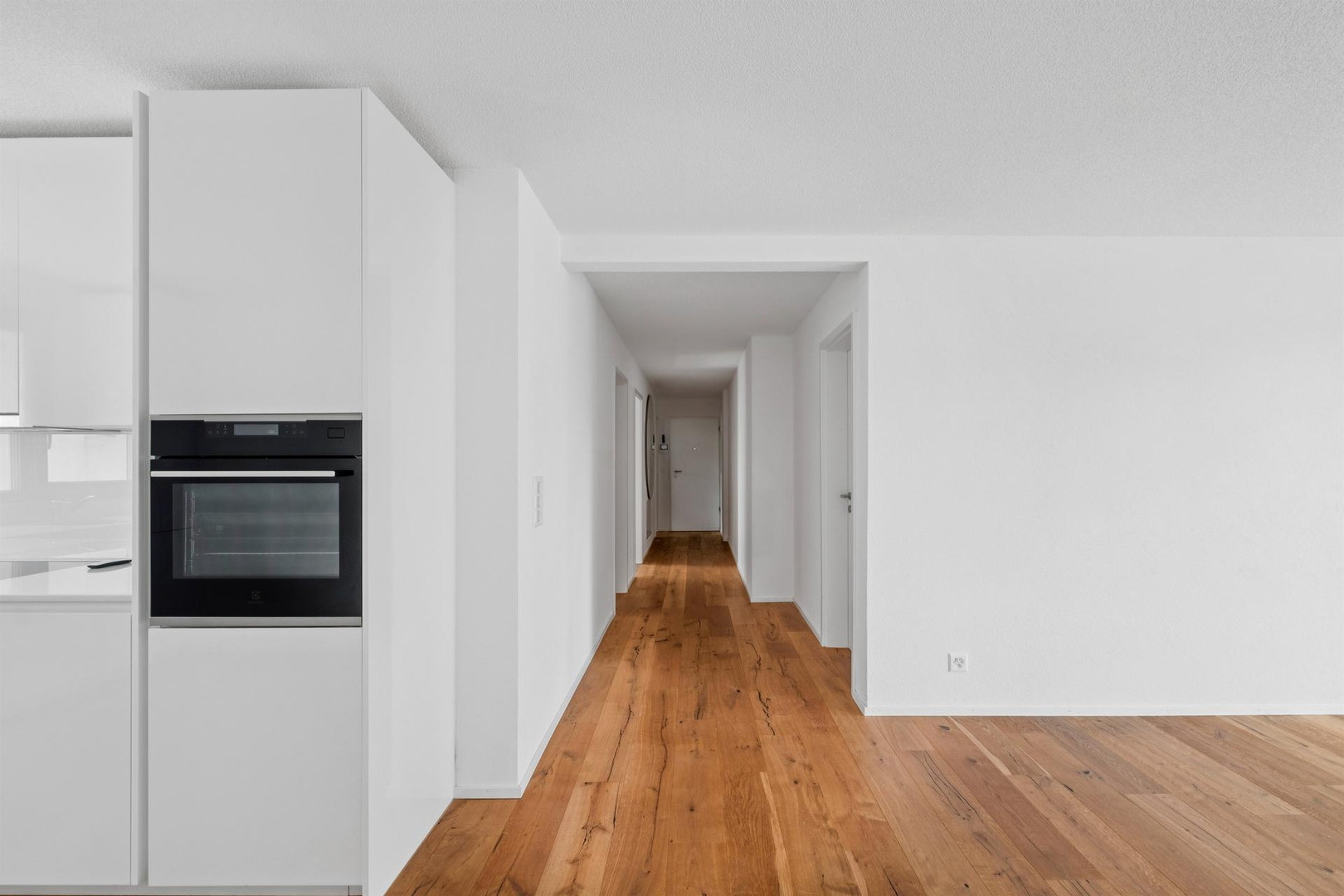 Minimalistischer Flur mit angrenzender offener Küche
