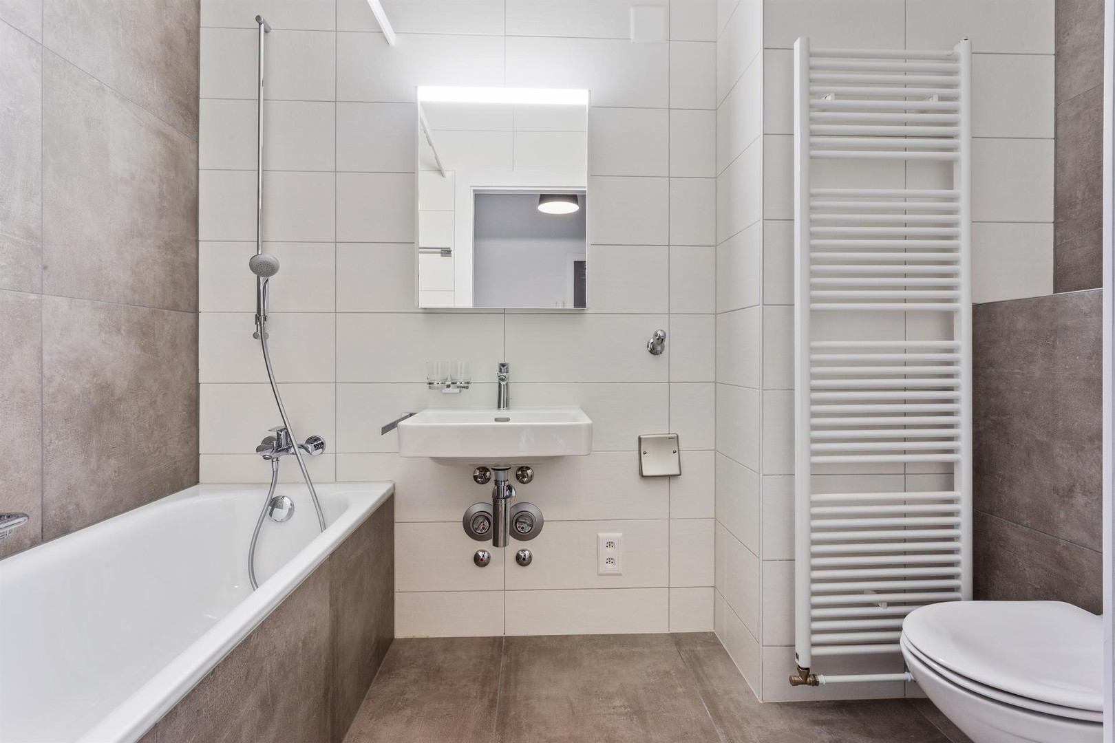 Modernes Badezimmer mit Badewanne und Wandheizkörper