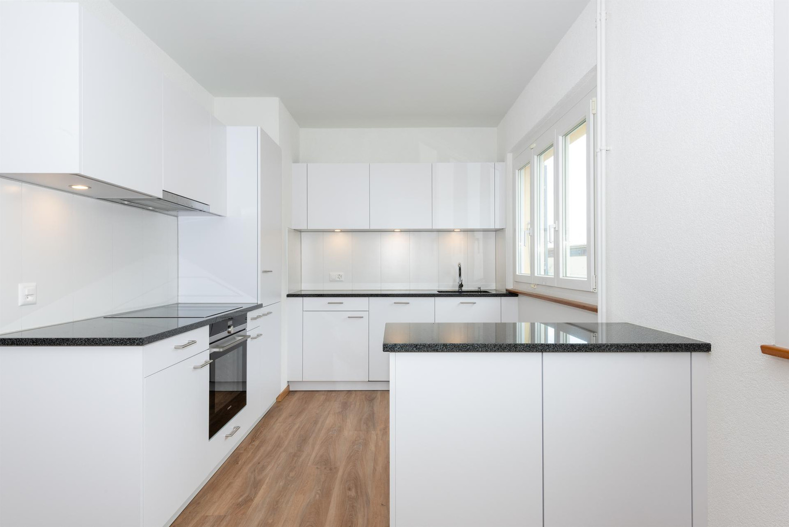 Moderne weiße Küche mit Kochzeile und Fenster