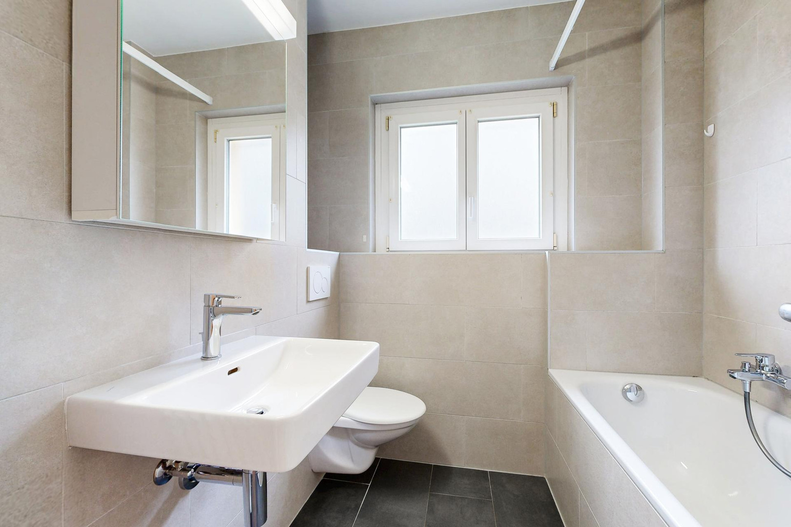 Modernes Badezimmer mit Badewanne und Wand-WC