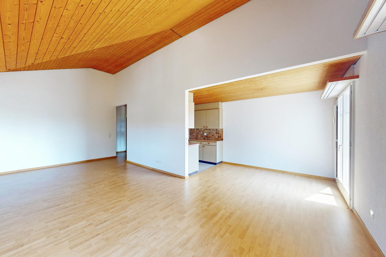 Heller Wohnraum mit offener Küchenzone und Holzdecke