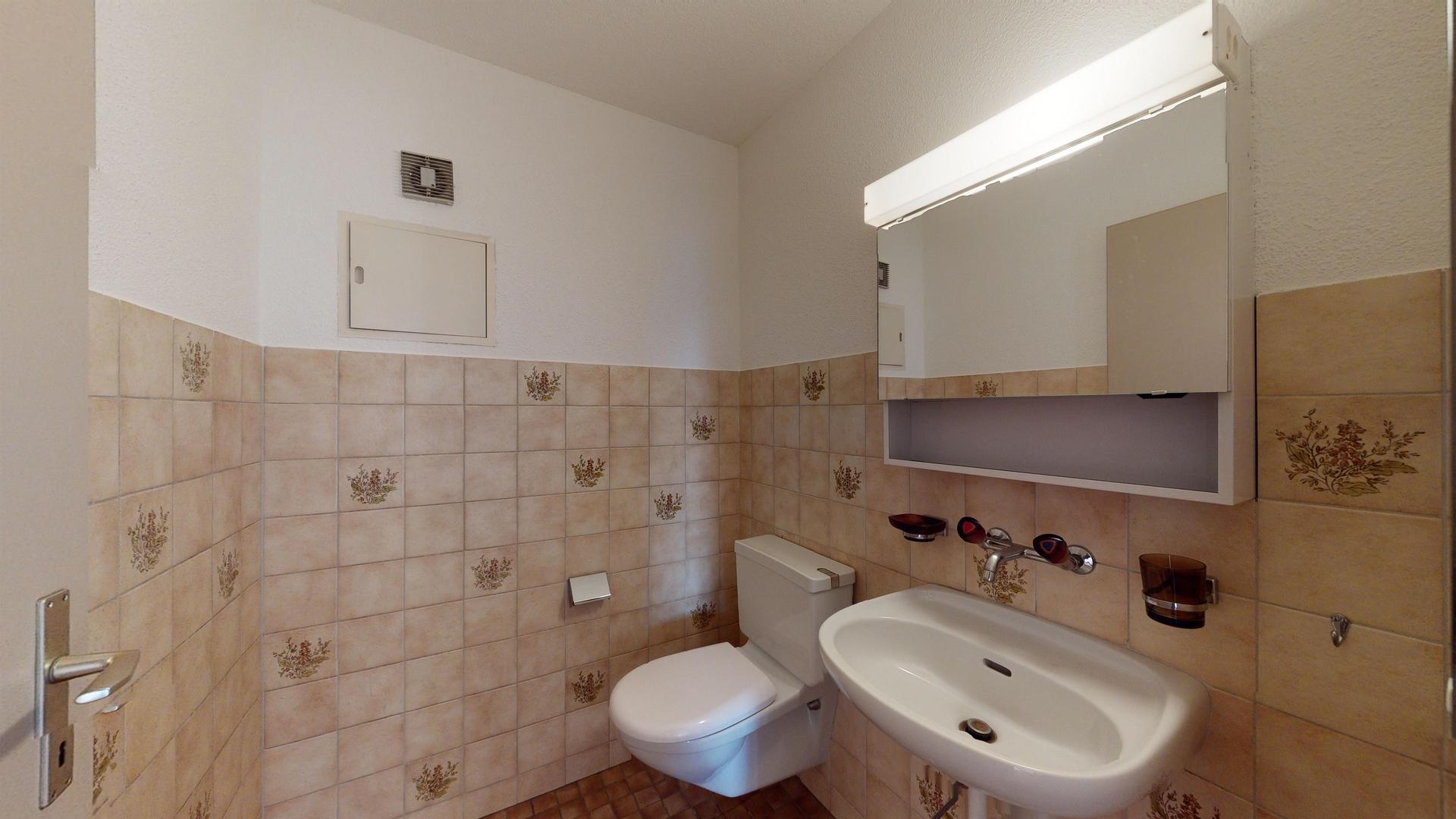 Gäste-WC mit Waschbecken und Spiegel
