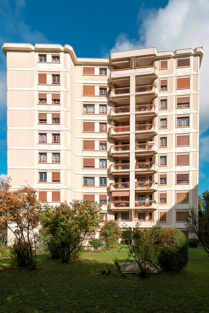 Wohnhochhaus mit Balkonen und Grünanlage