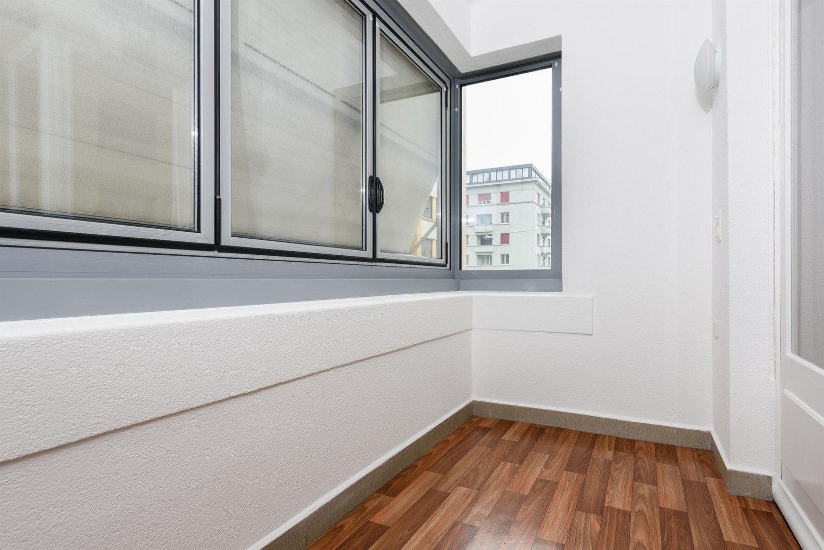 Heller kleiner Innenraum mit Fenster und Holzboden