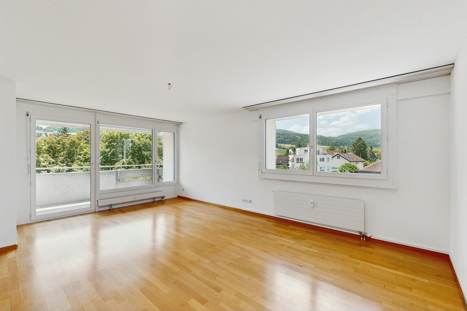 Heller leerer Wohnraum mit Balkon und Bergblick