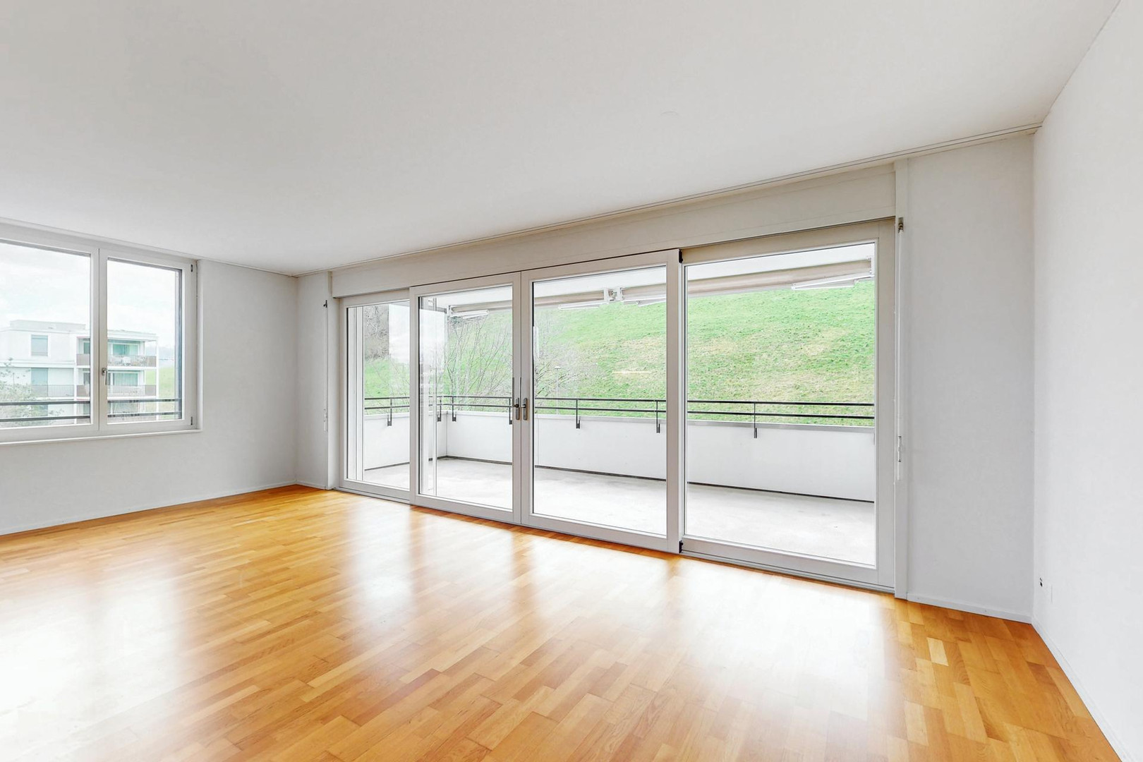 Heller Wohnraum mit Balkon und Parkettboden