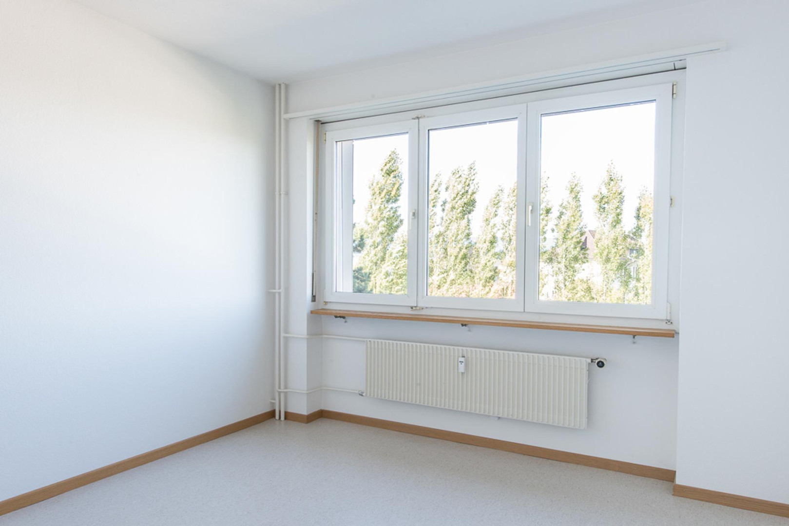 Helles, leeres Zimmer mit großem Fenster