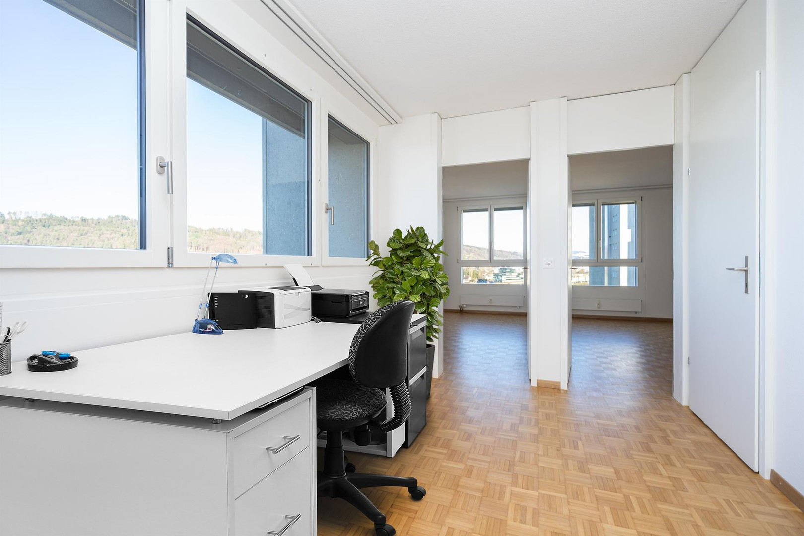 Helles Arbeitszimmer mit großem Fenster und Bergblick
