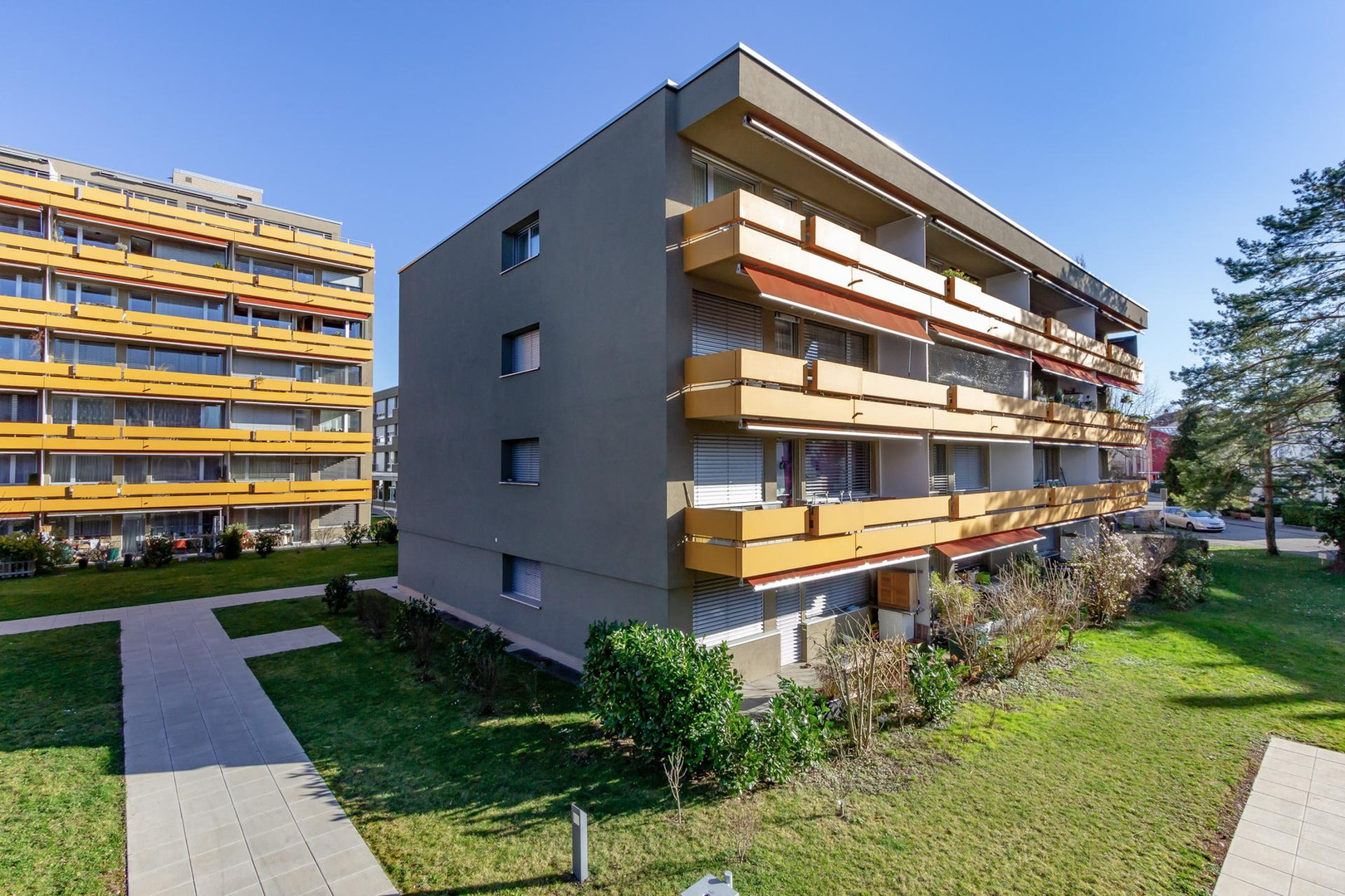 Mehrfamilienhaus mit Balkonen und Grünanlage