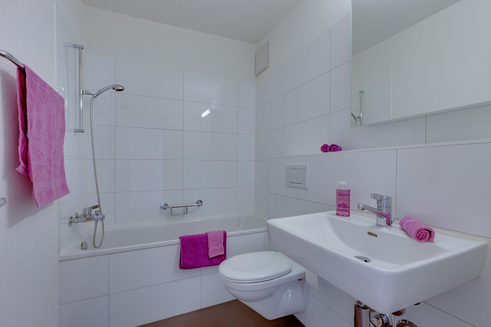 Helles Badezimmer mit Badewanne, Wand-WC und Waschtisch