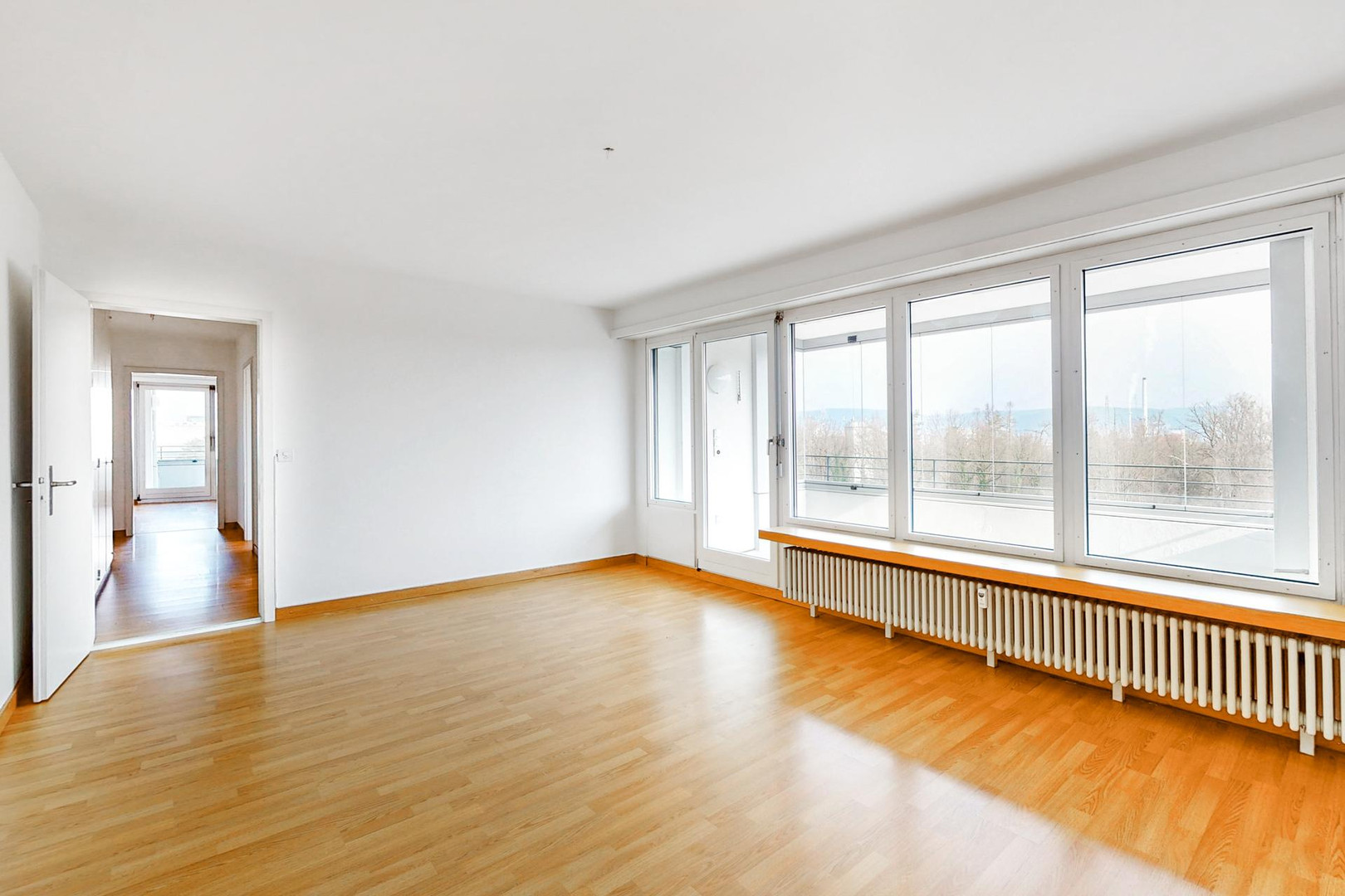 Heller leerer Wohnraum mit großen Fenstern