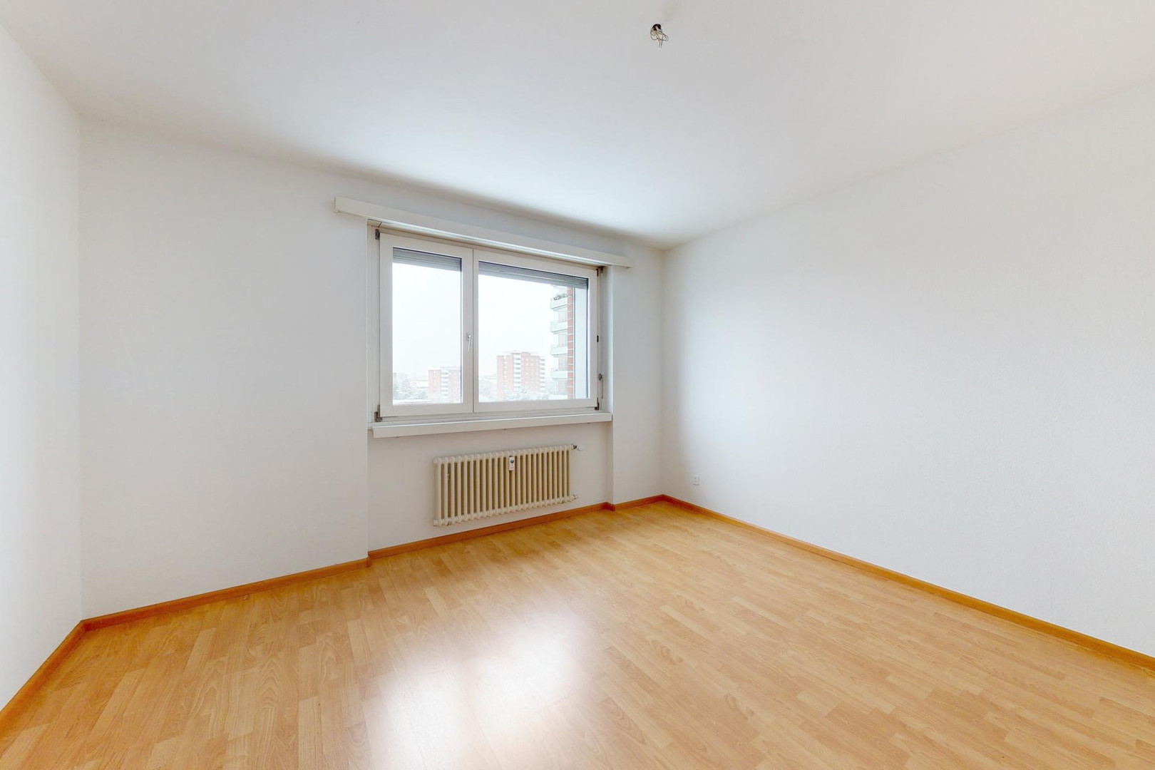 Leeres Zimmer mit Fenster und Heizkörper