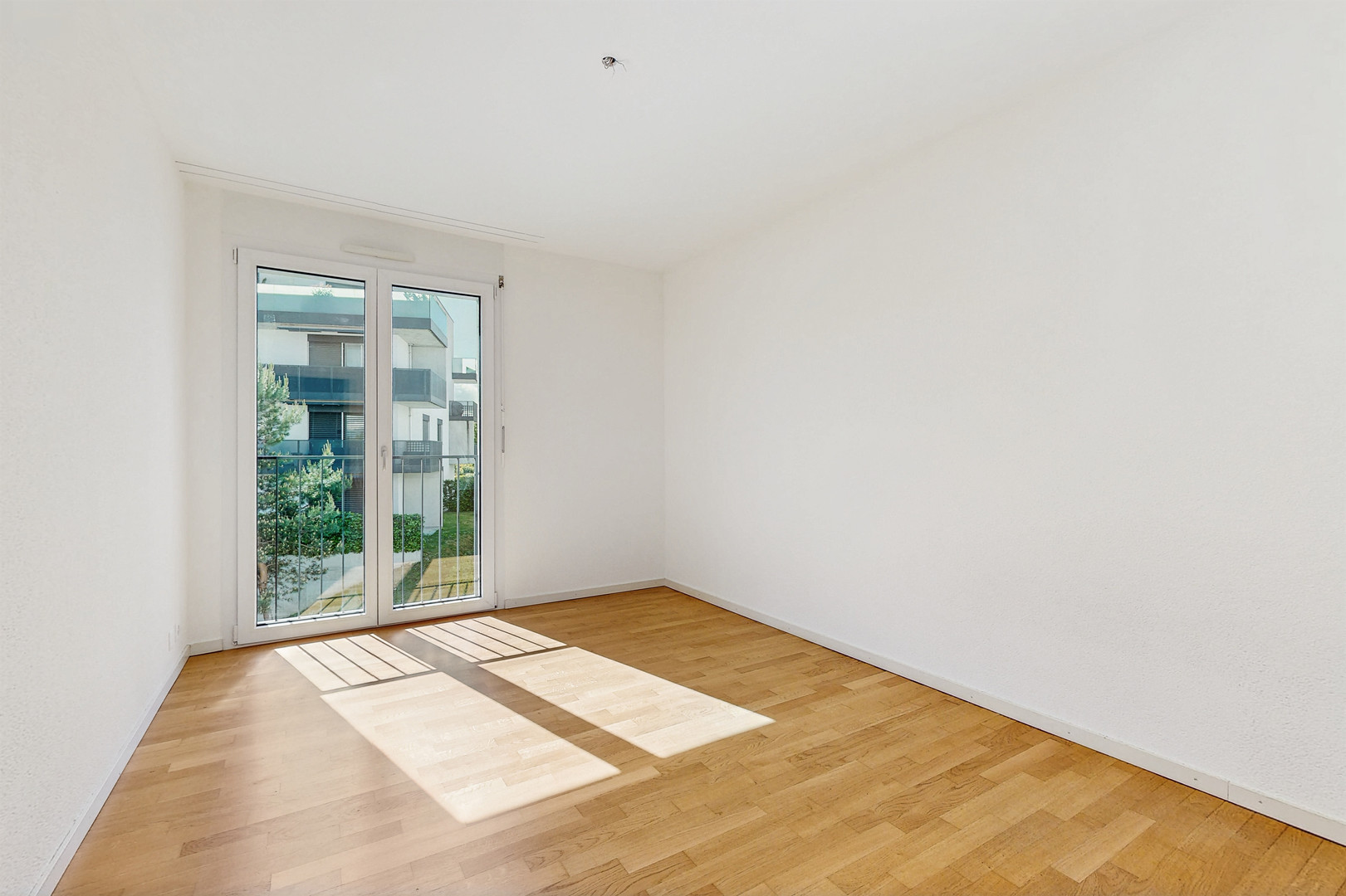Helles, leeres Zimmer mit Balkonfenster