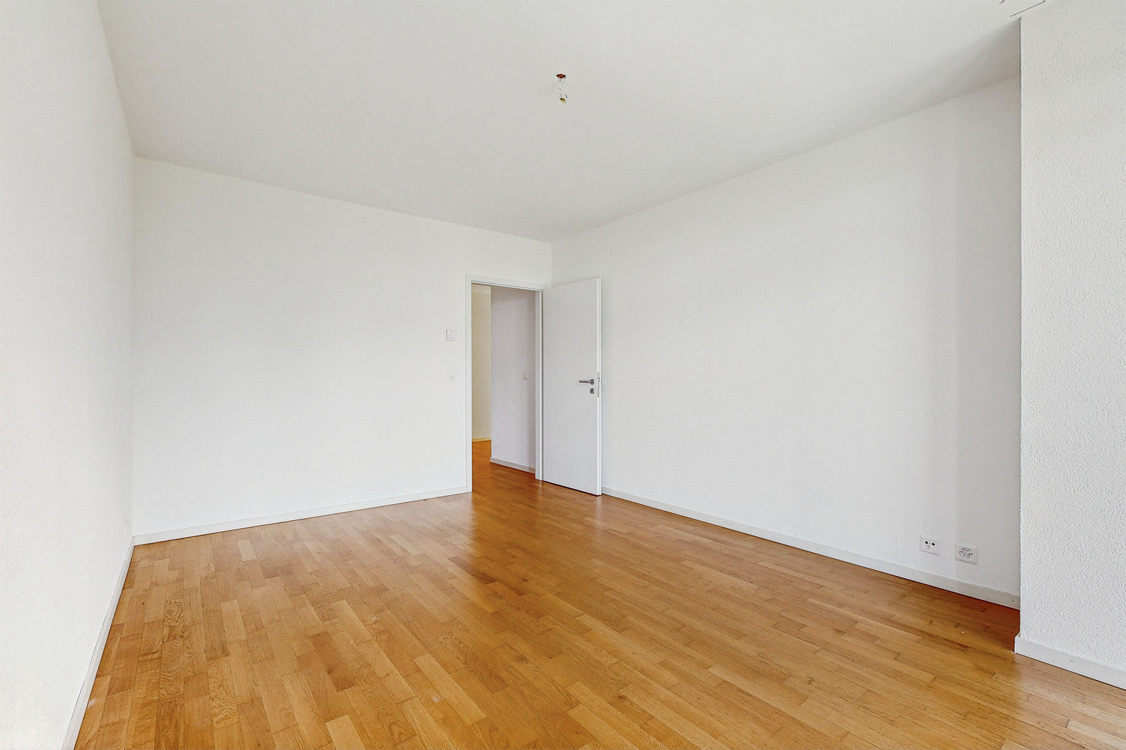 Leeres, frisch renoviertes Zimmer mit Parkettboden