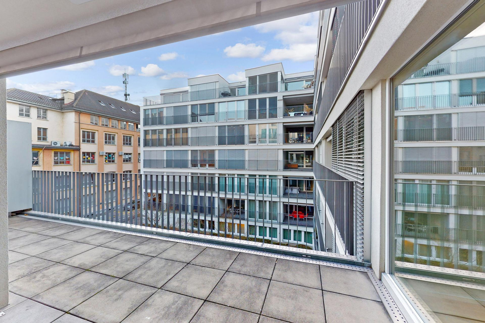 Große Balkonterrasse mit Blick auf umliegende Wohngebäude
