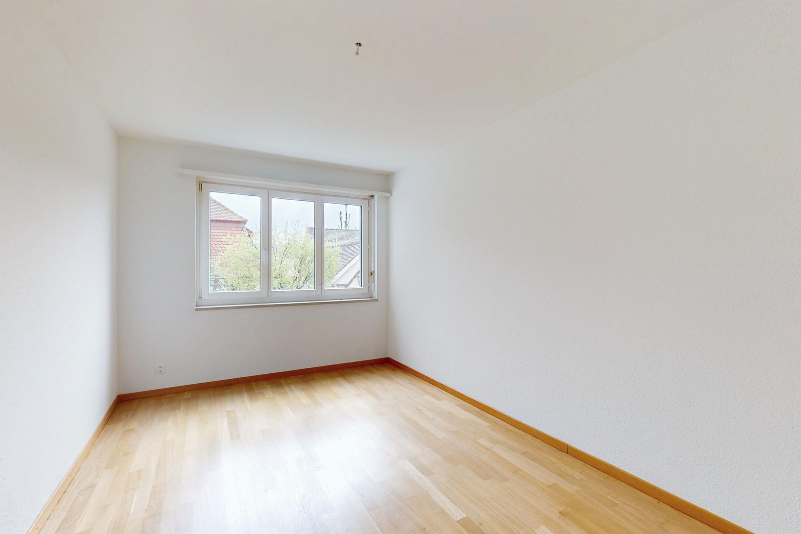 Heller, leerer Wohnraum mit Fenster