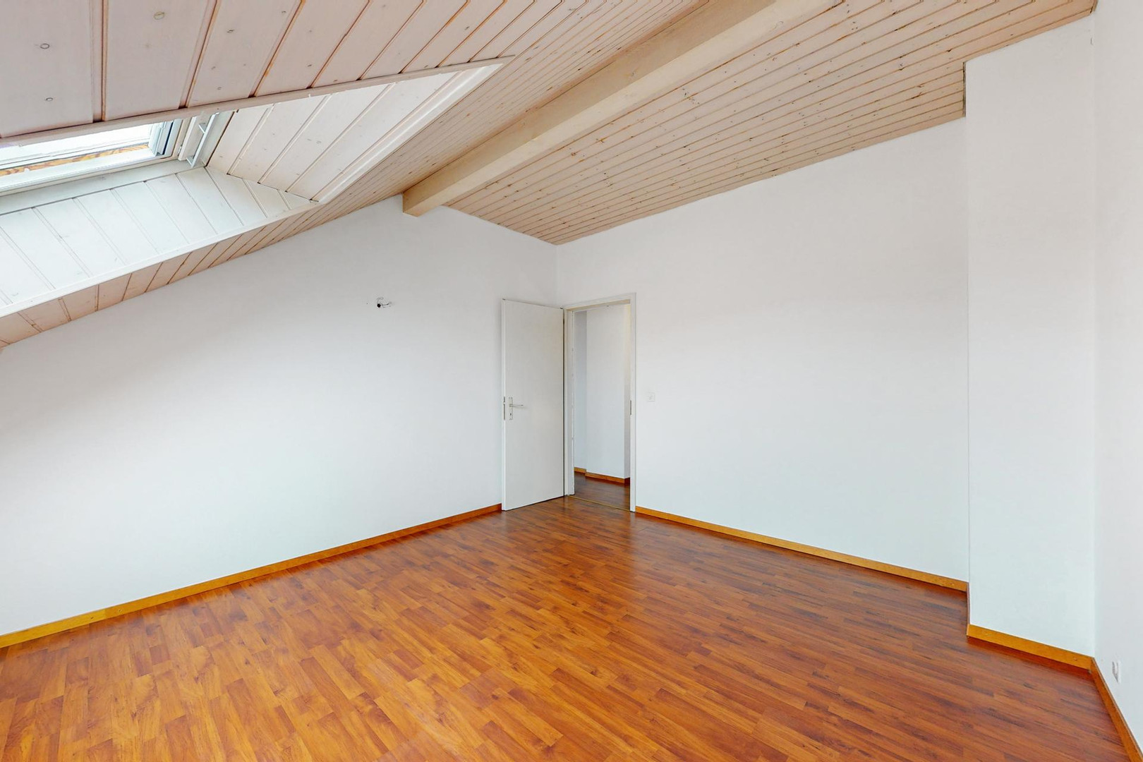 Ausgebauter Dachraum mit Holzdecke und Dachfenster