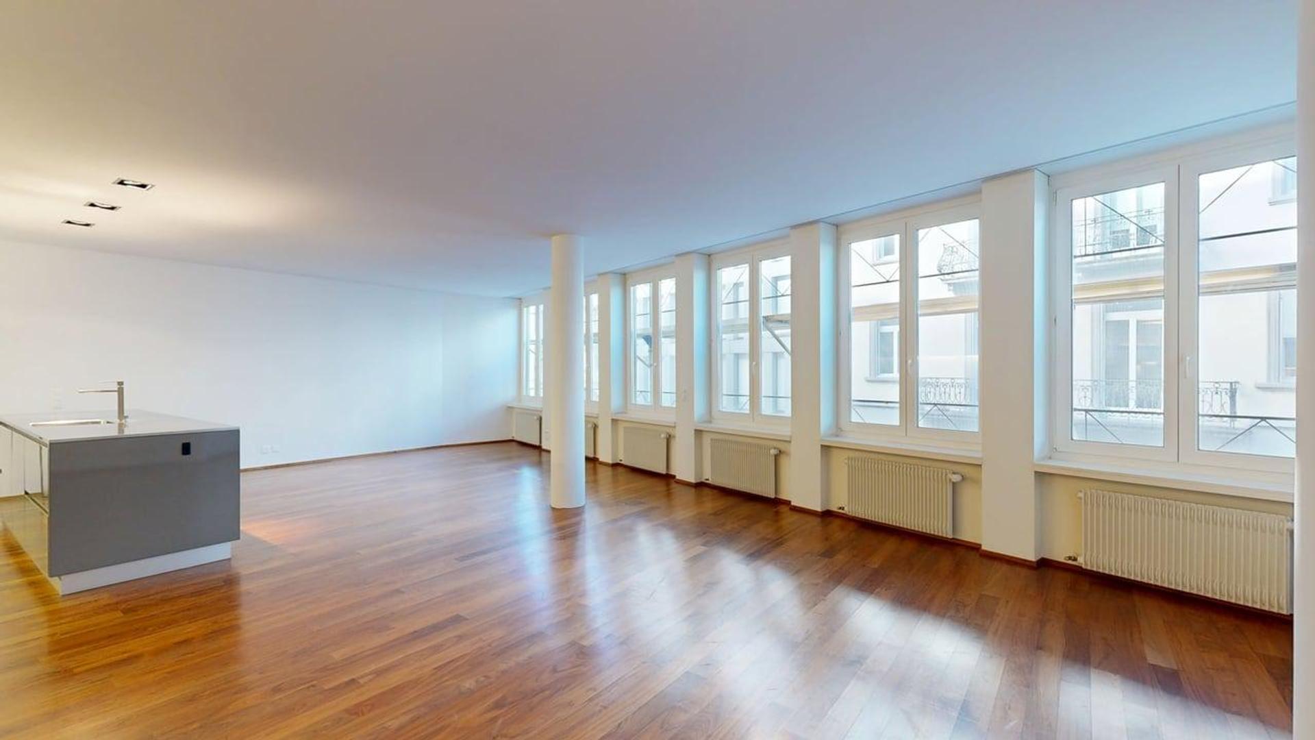 Großer, leerer Wohnraum mit Fensterfront
