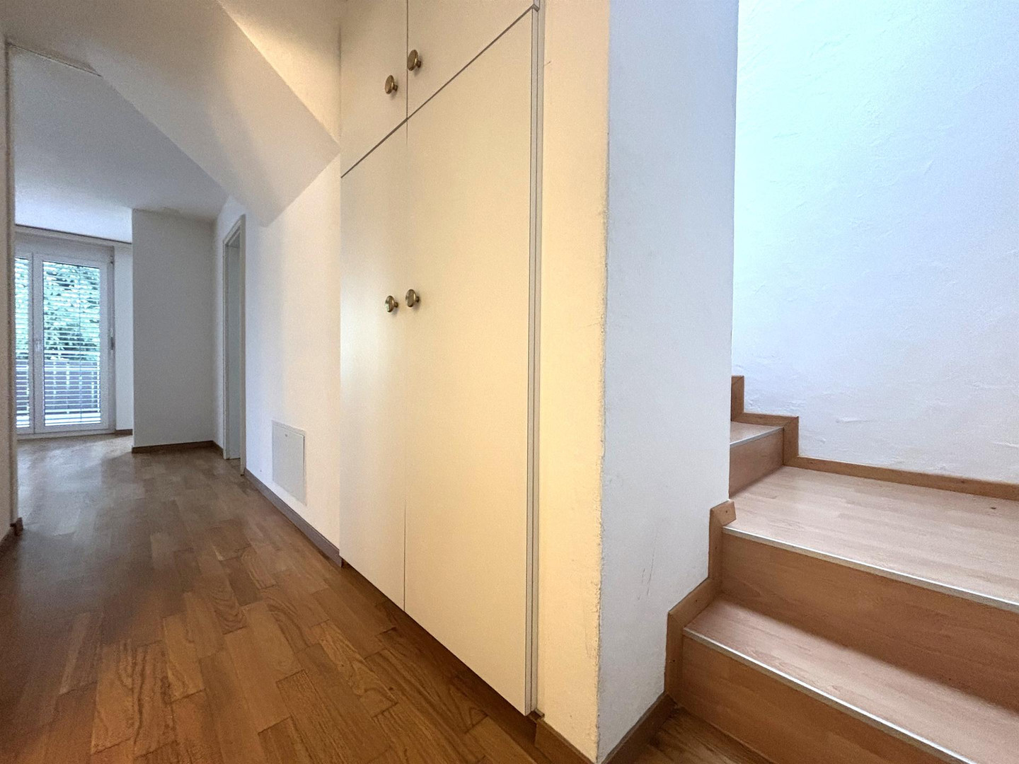 Heller Flur mit Treppe und Einbauschrank