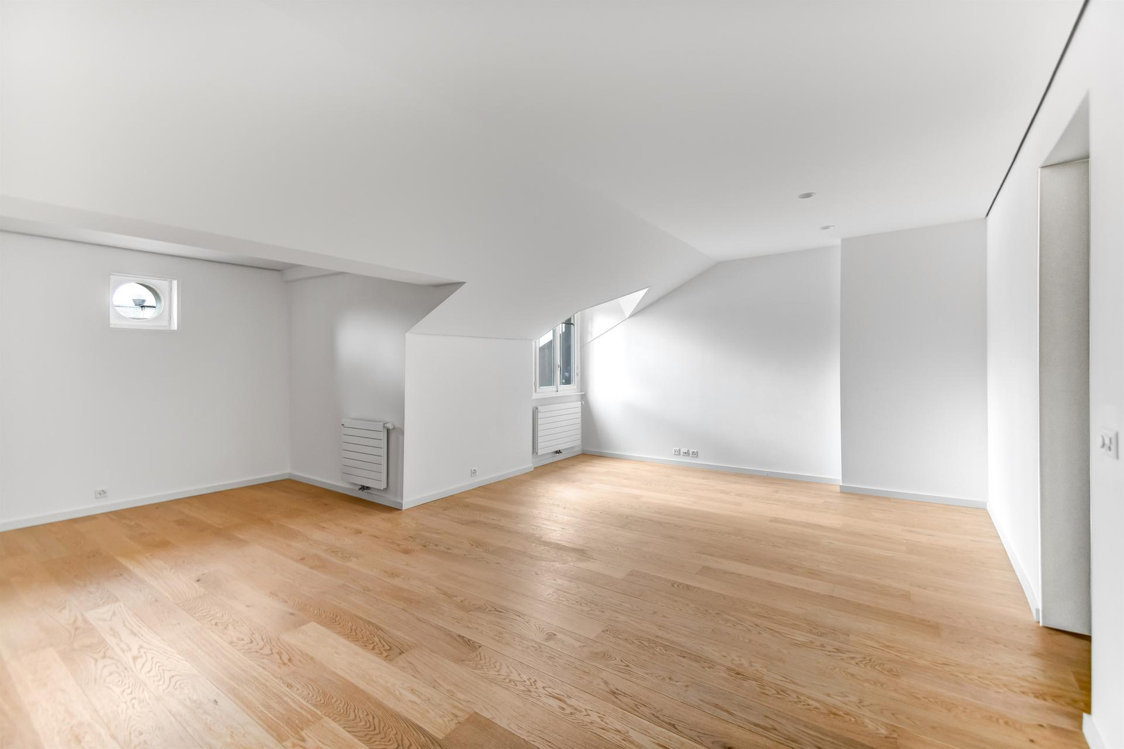 Heller, leerer Dachraum mit Holzparkett
