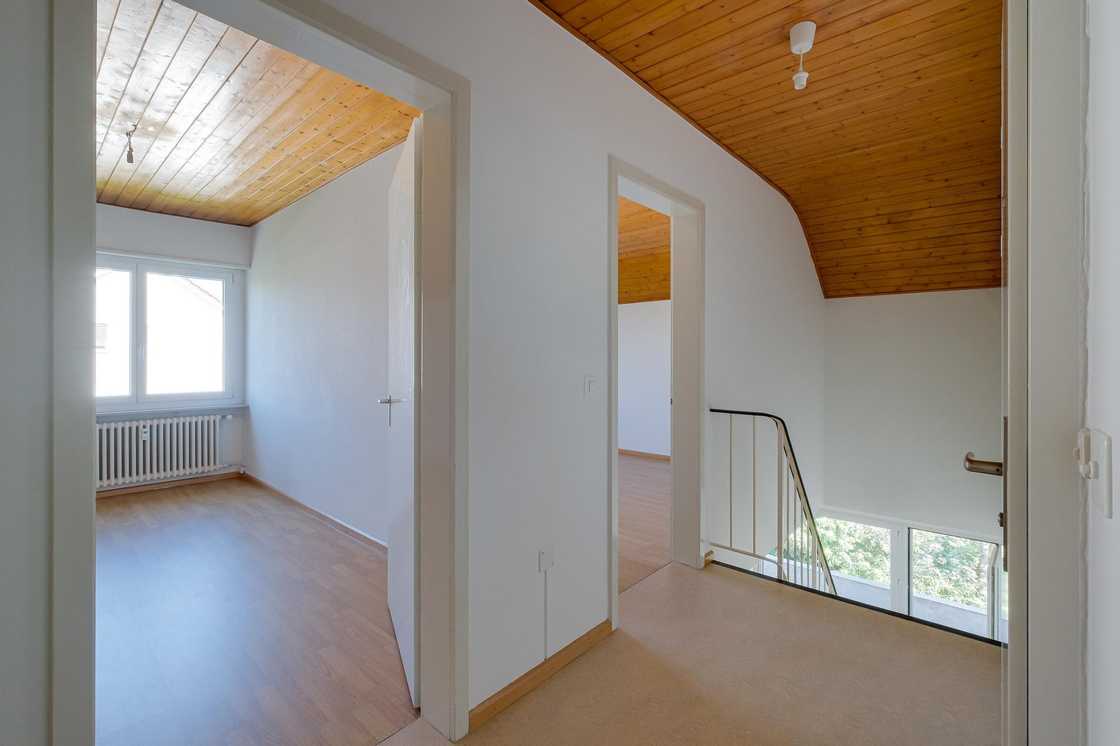 Heller Dachgeschossflur mit Holzdecke und Treppenpodest