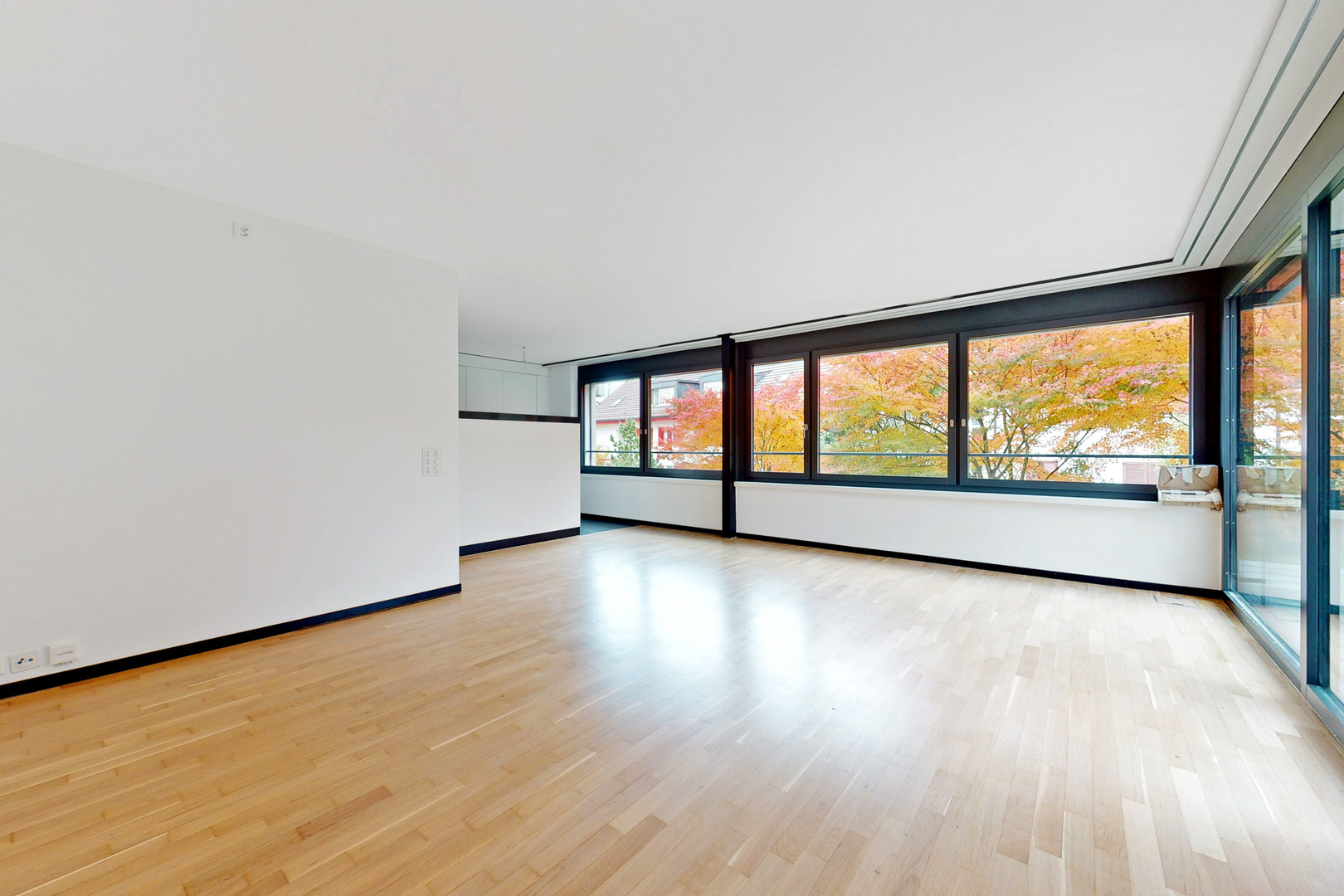 Heller, leerer Wohnraum mit großen Fensterflächen