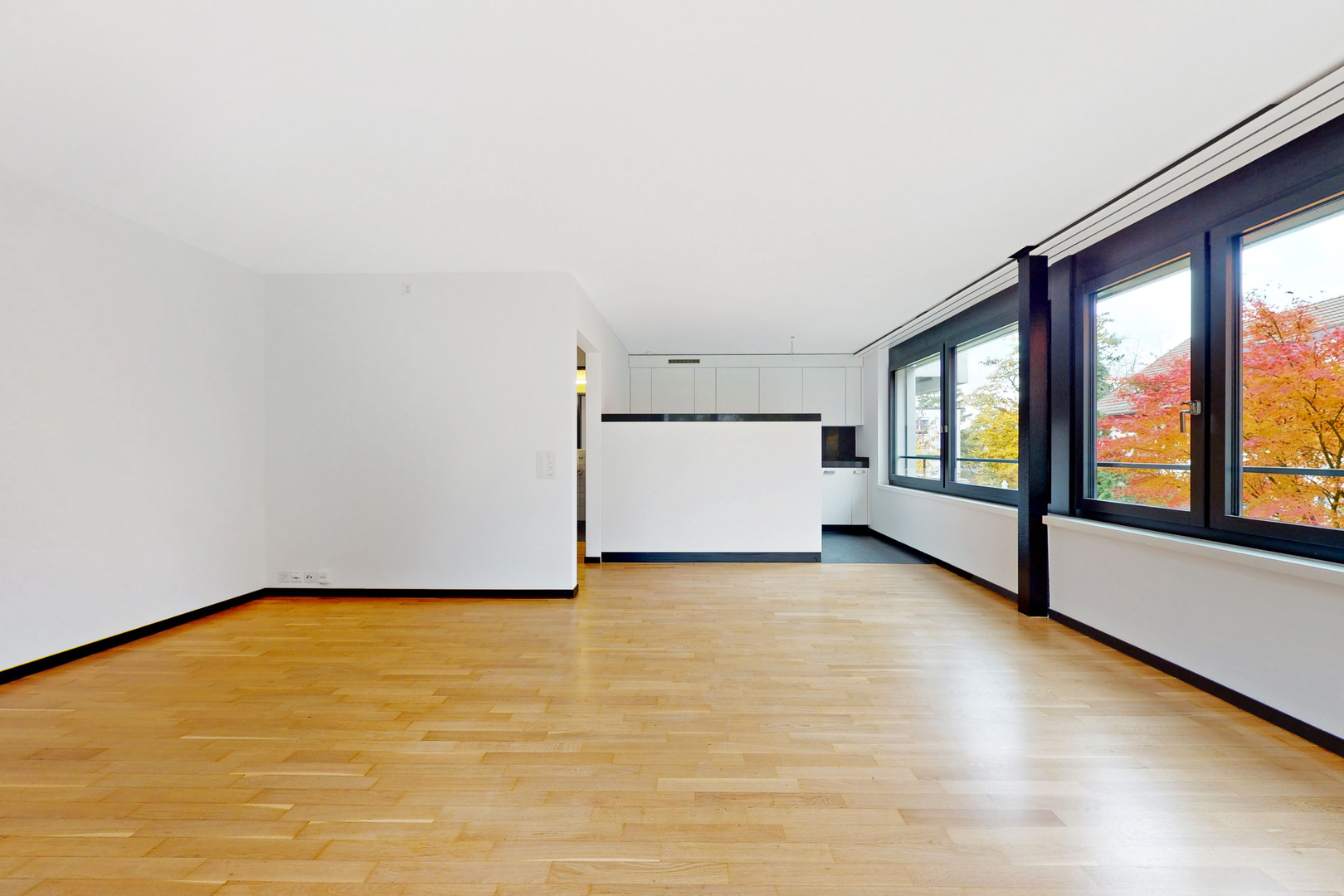 Heller Wohnraum mit Fensterfront und offener Küche
