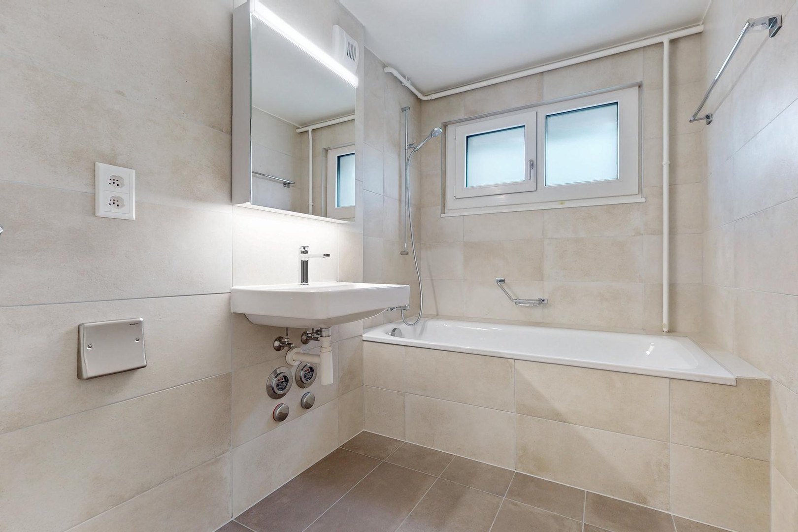 Helles Badezimmer mit Badewanne und Fenster