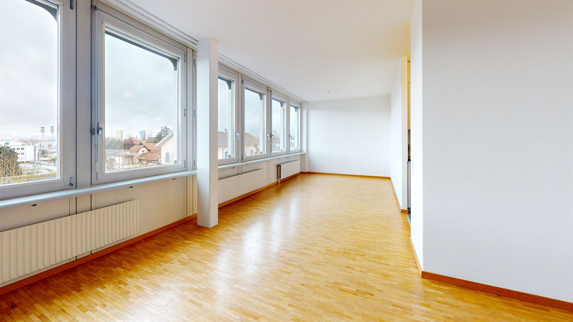 Heller leerer Wohnraum mit großen Fenstern
