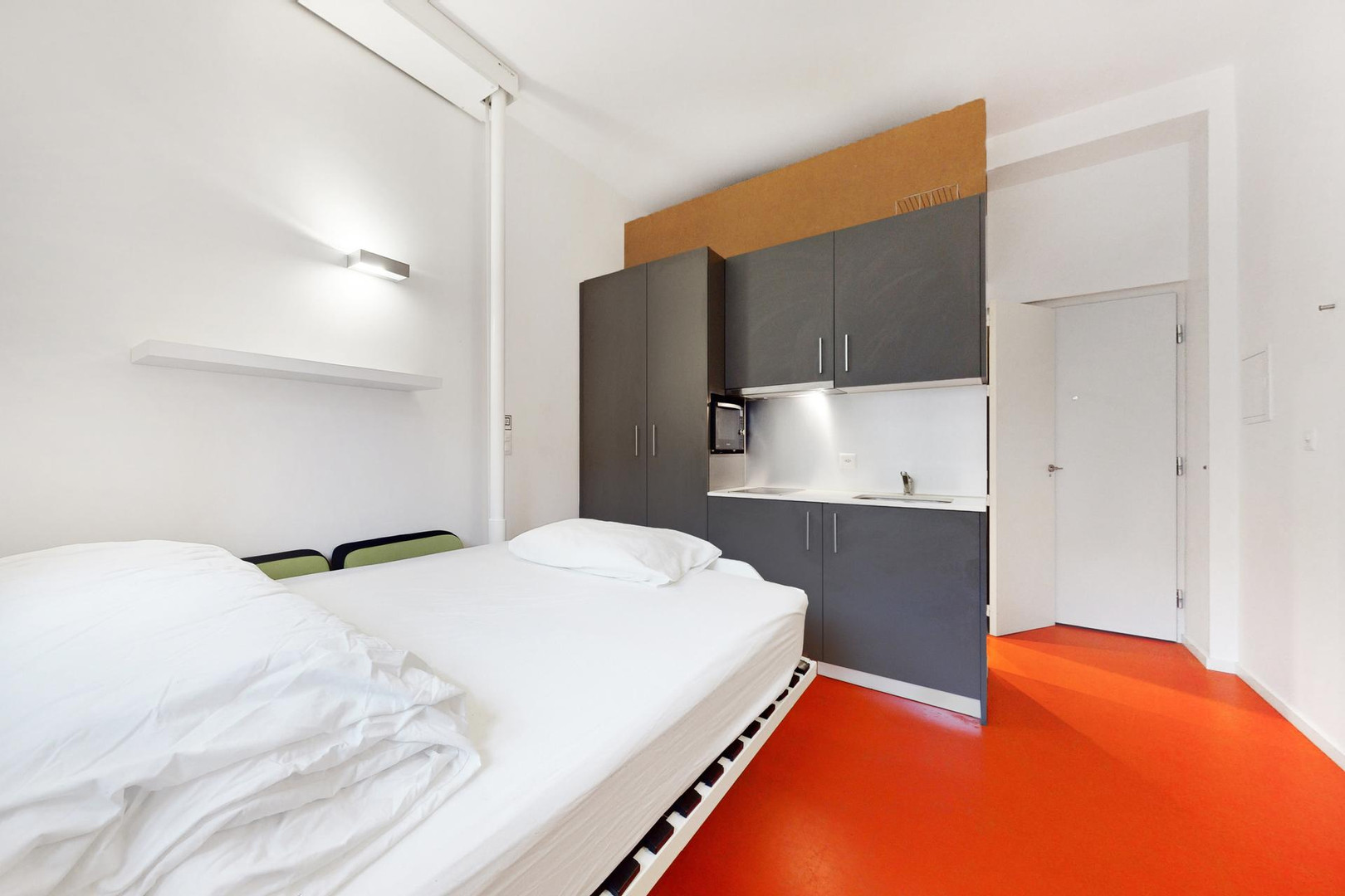 Kleines Studiozimmer mit Bett und Küchenzeile