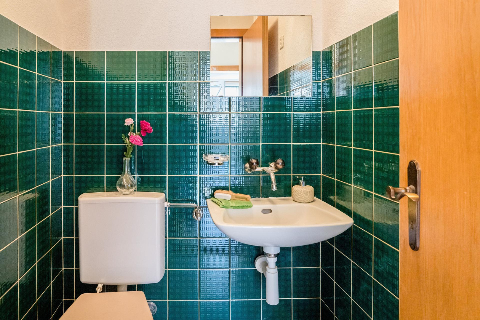 Gäste-WC mit grünen Wandfliesen