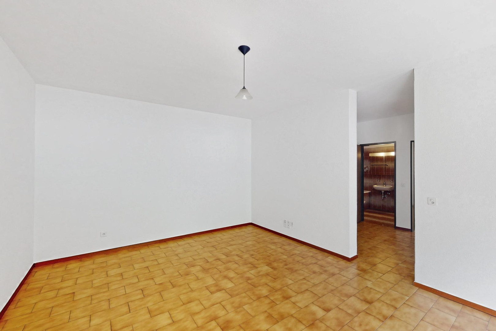 Leerer Wohnraum mit Fliesenboden