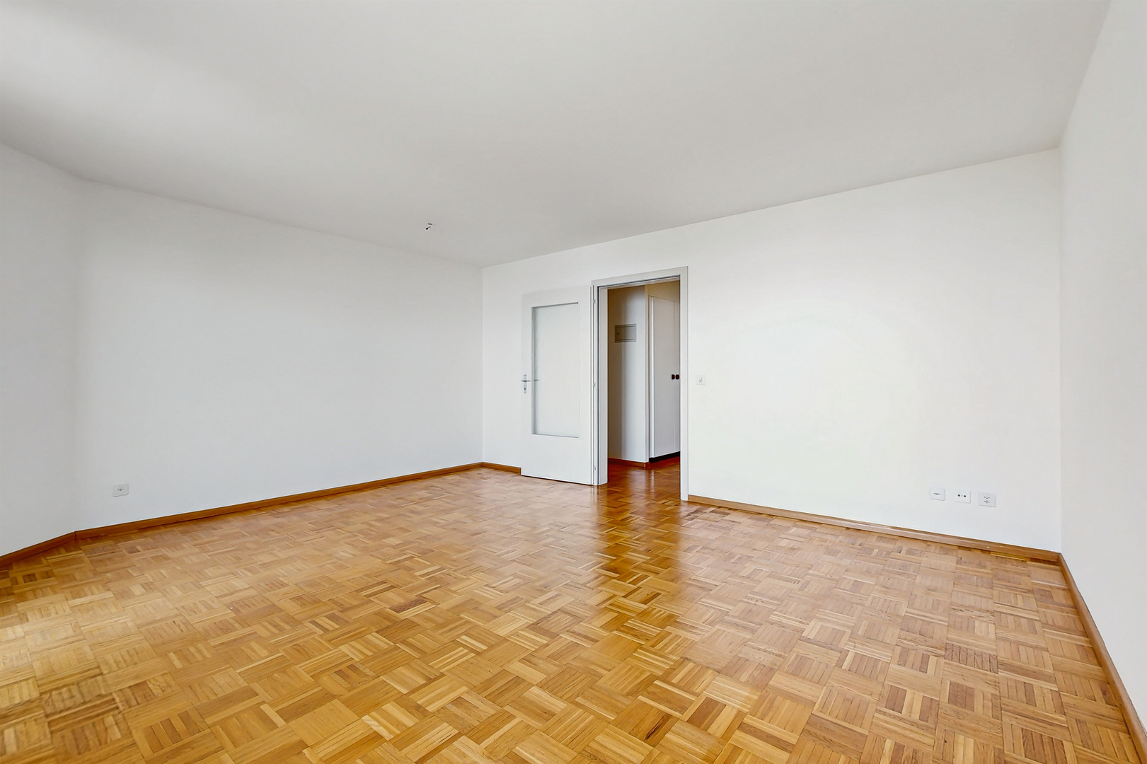 Leerer Wohnraum mit Parkettboden