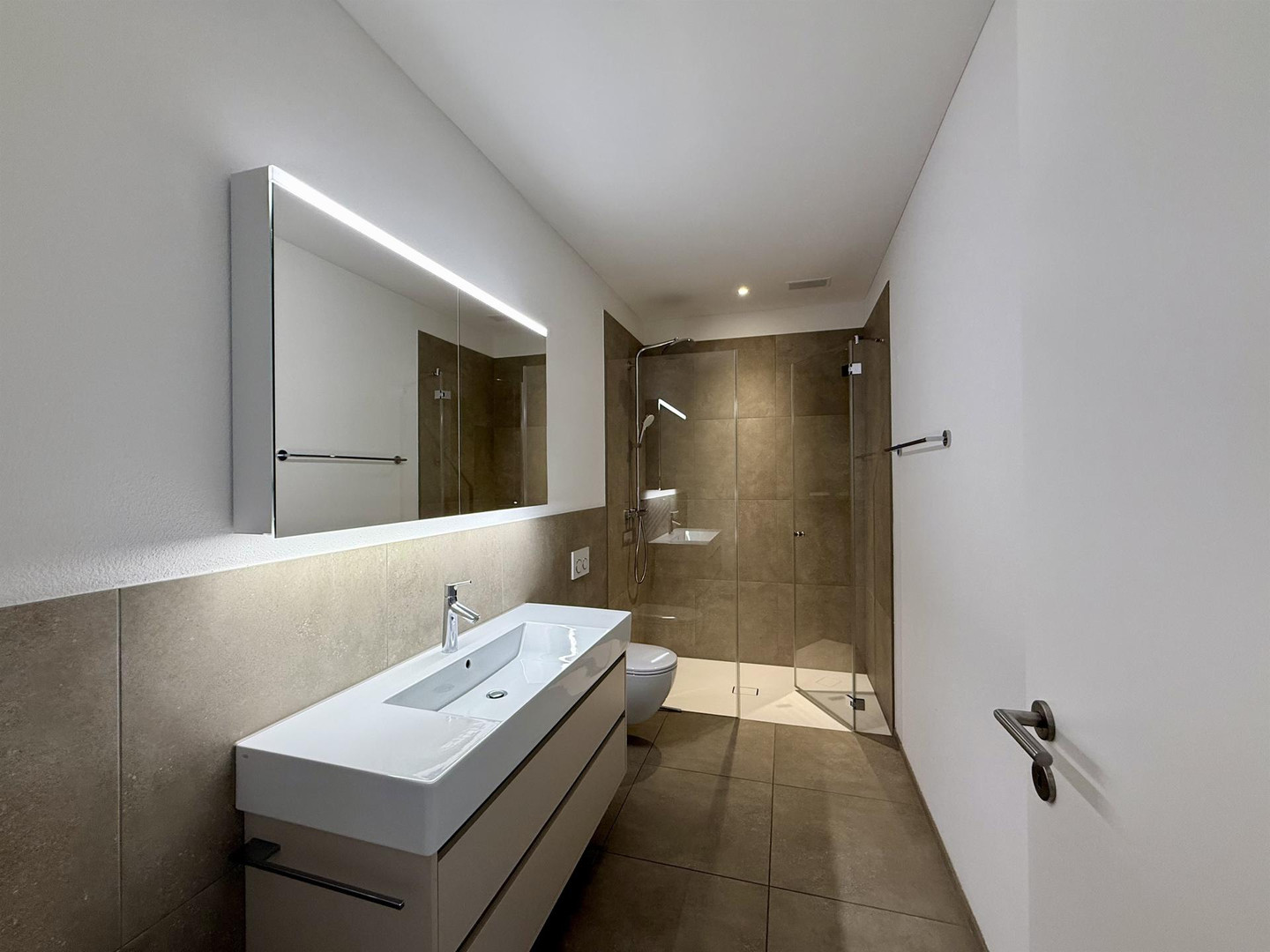 Modernes Bad mit Dusche und Waschtisch