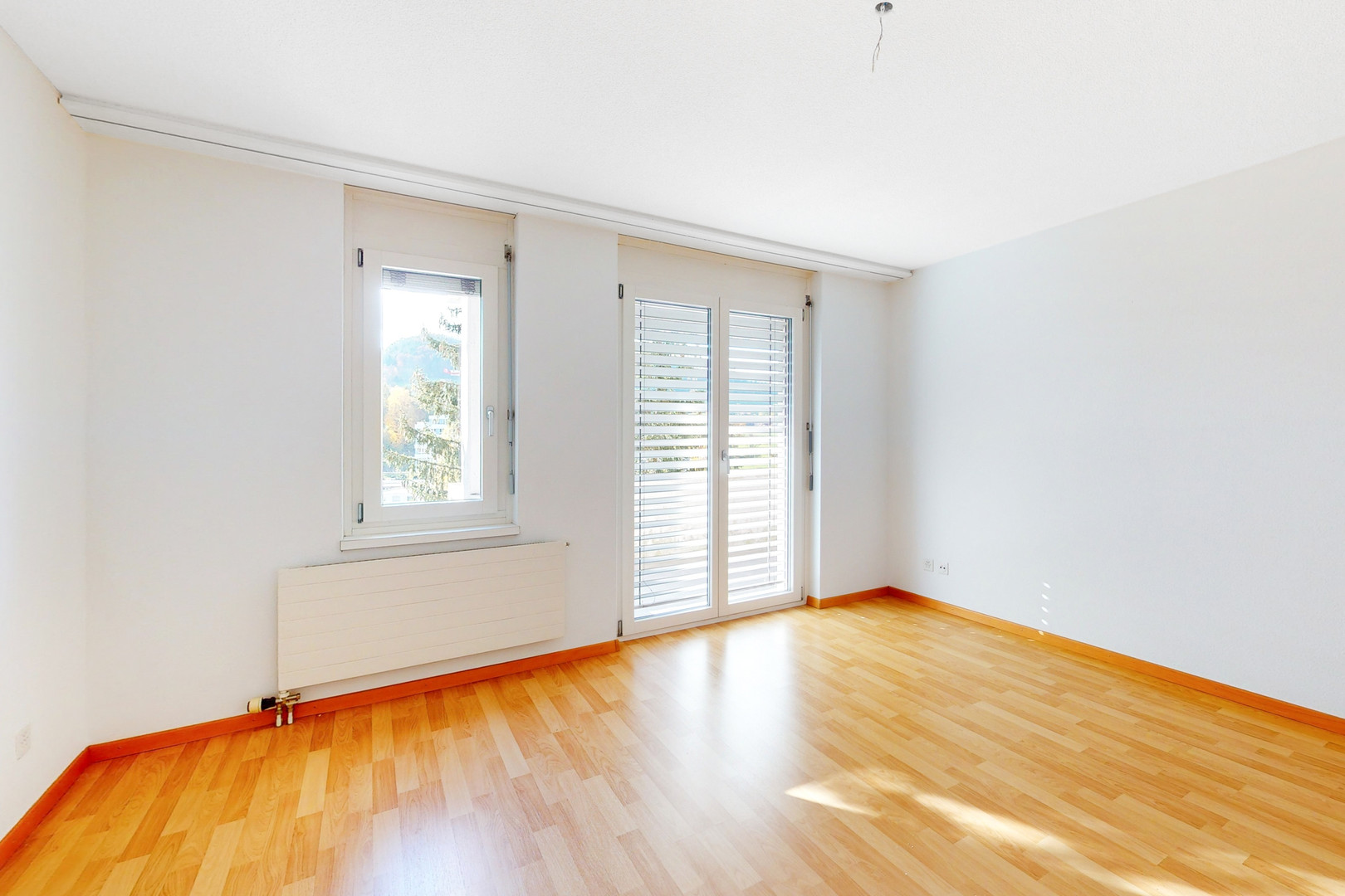 Helles leeres Zimmer mit Balkon-/Fenstertür