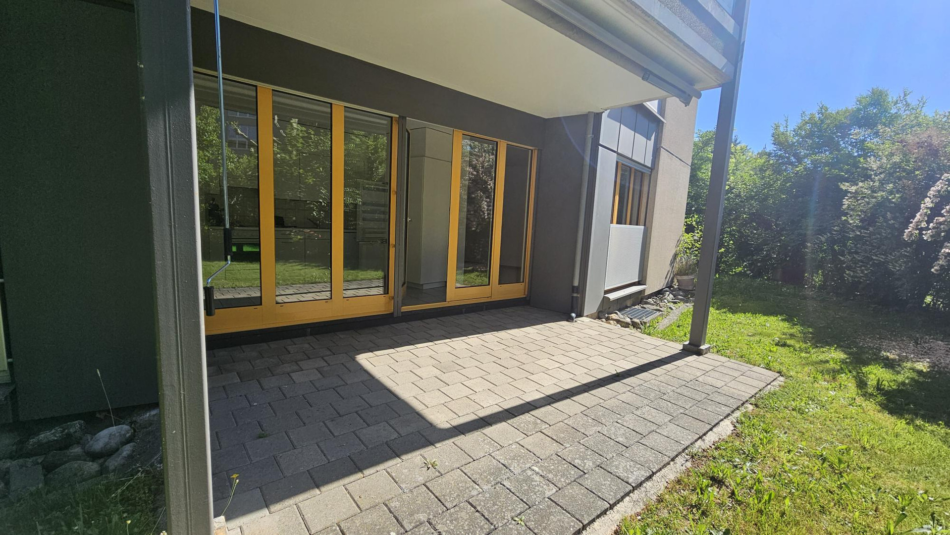 Überdachte Terrasse mit großen Glasfronten