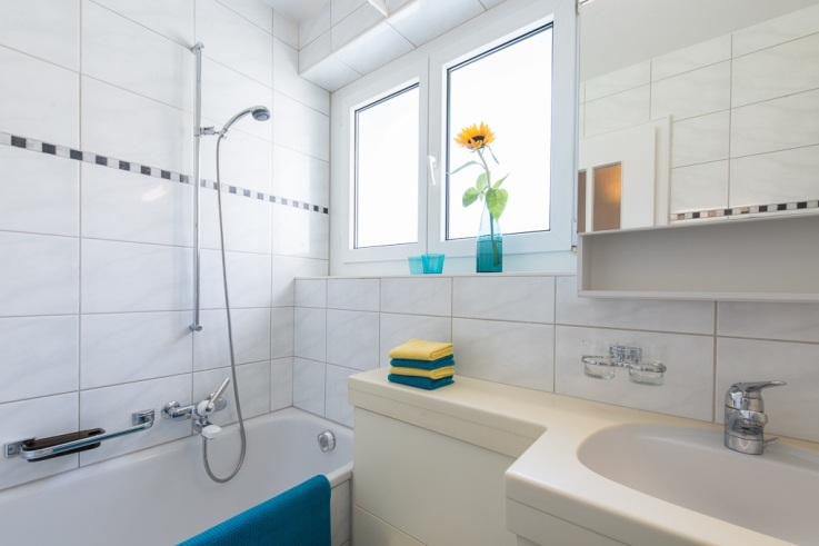 Helles Badezimmer mit Badewanne und Fenster