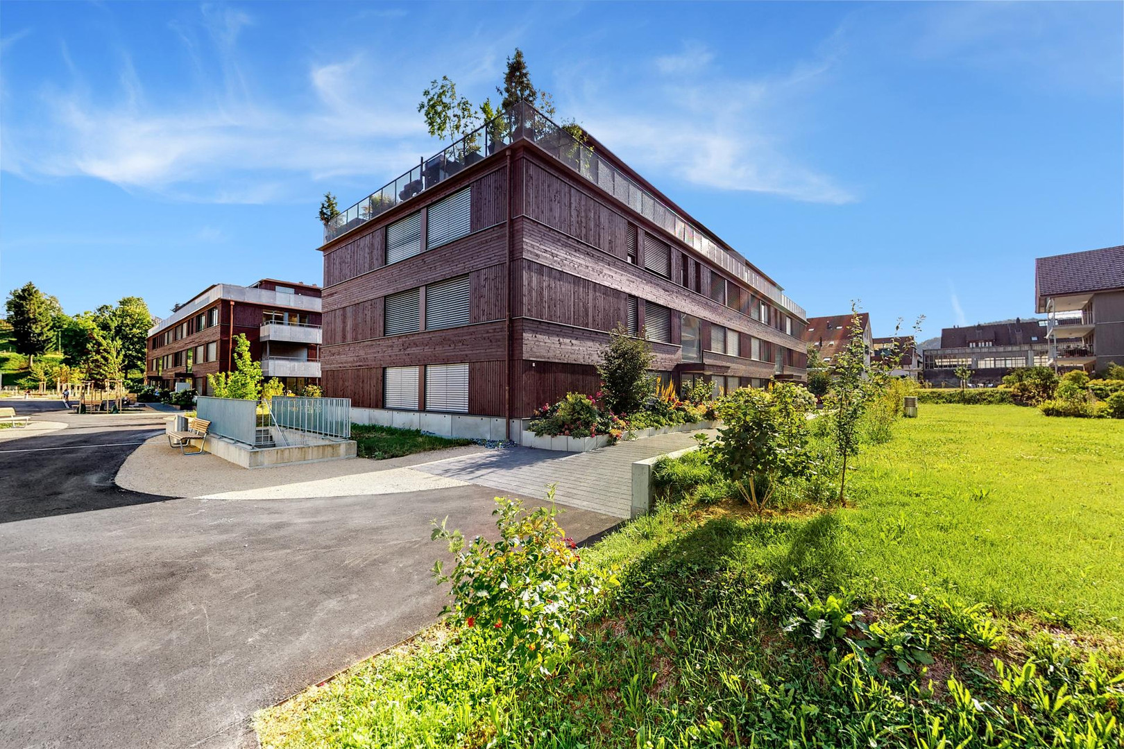 Modernes Wohngebäude mit Holzfassade und Dachterrasse