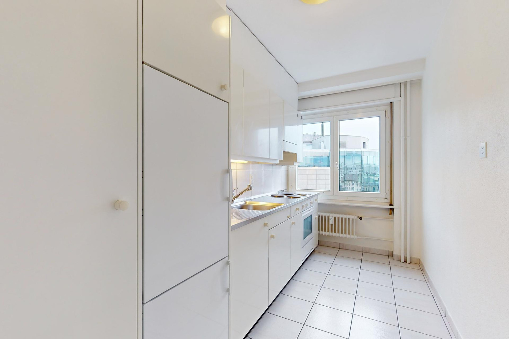 Schmale weiße Küche mit Fenster