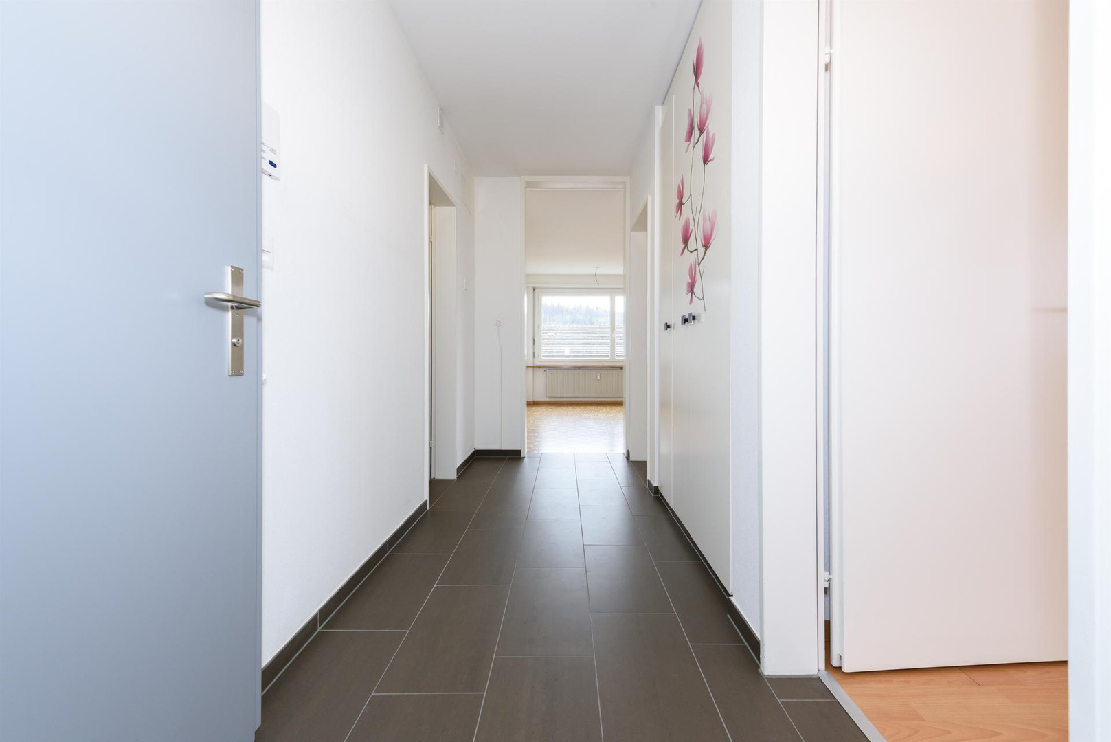 Heller Flur mit Blick in einen Wohnraum