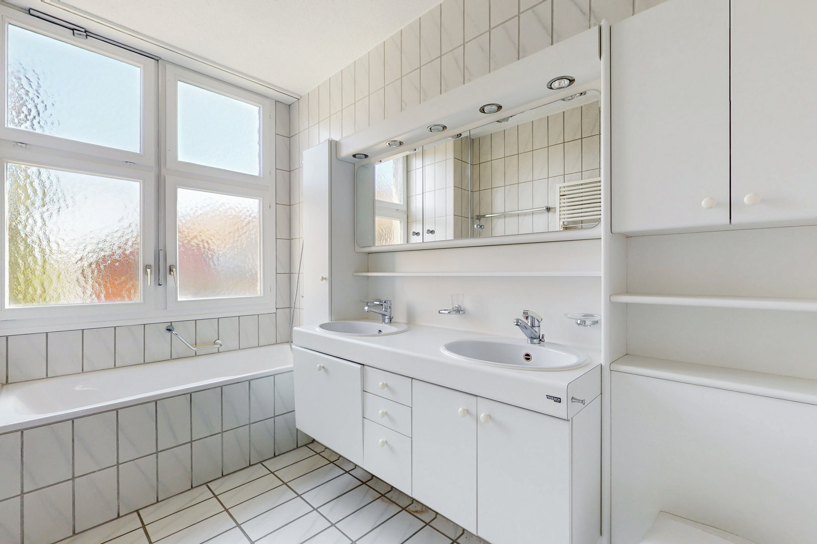 Helles Badezimmer mit Doppelwaschtisch und Badewanne