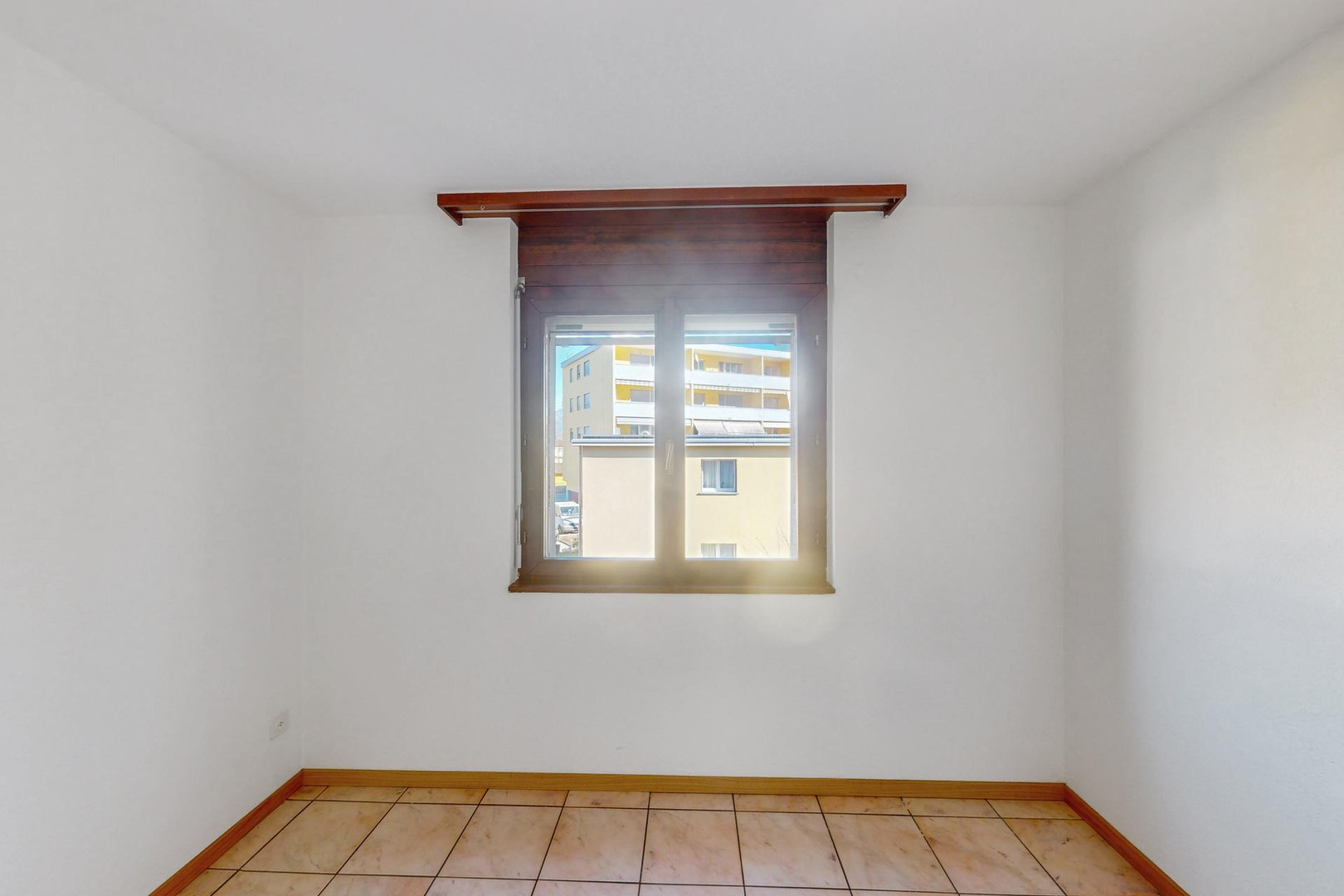 Leerer Raum mit Fenster und Fliesenboden