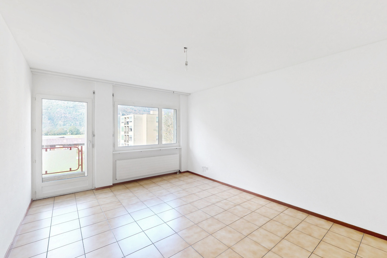Leerer heller Raum mit Balkon und Fensterblick