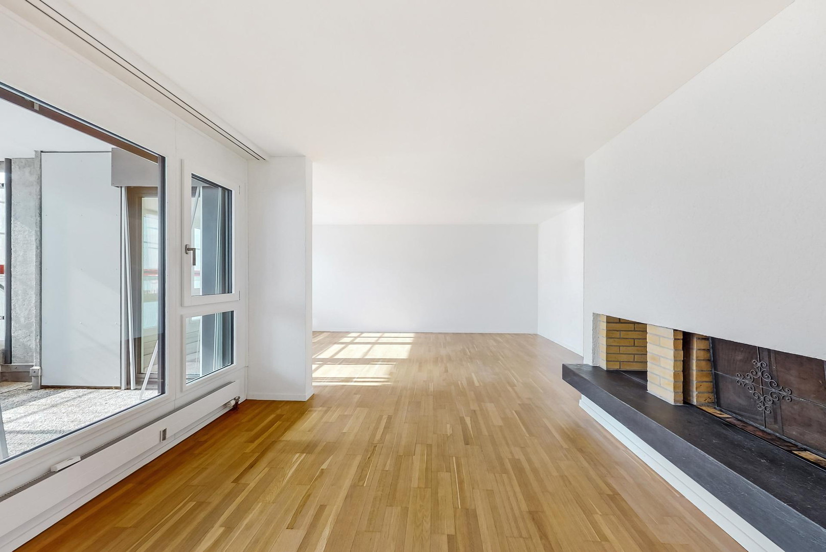 Helles Wohnzimmer mit Kamin und Balkonzugang