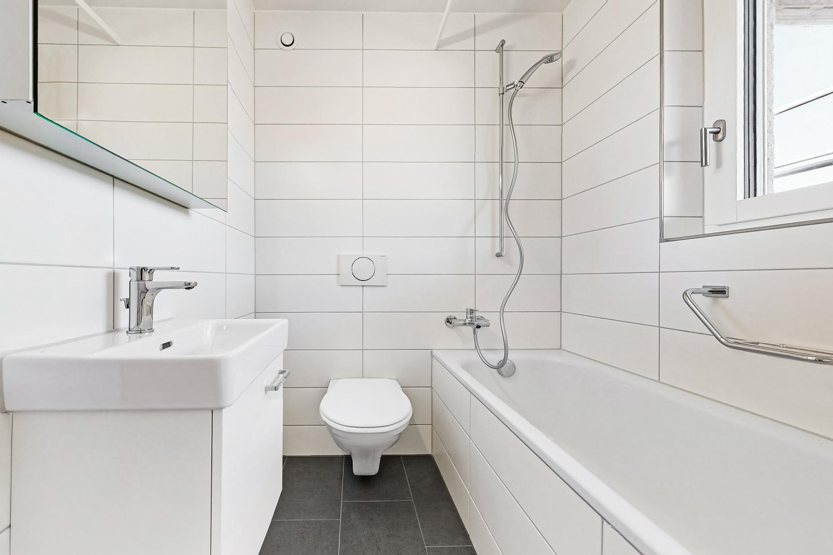 Kleines modernes Badezimmer mit Badewanne und WC