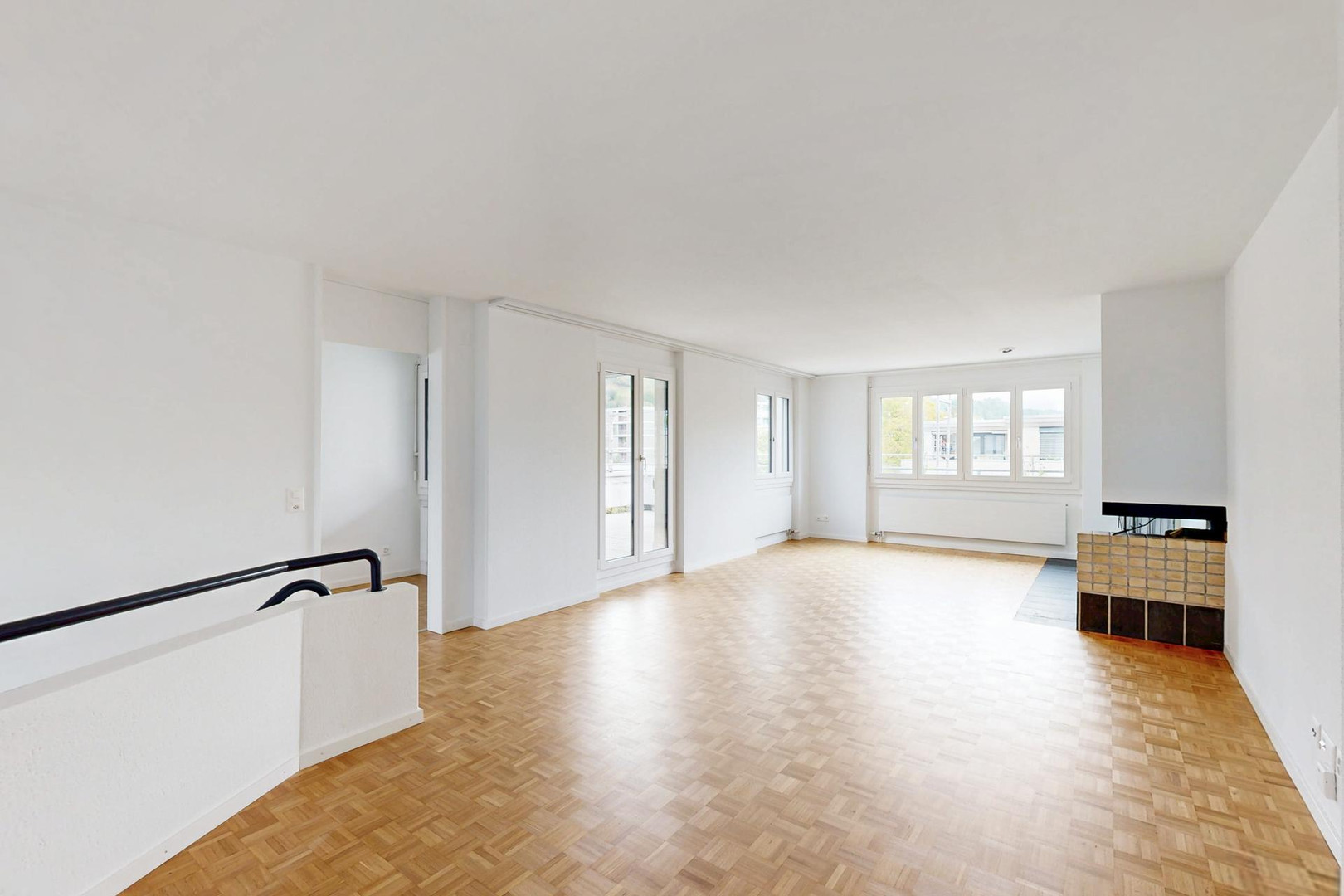 Heller leerer Wohnraum mit Parkett und Kamin